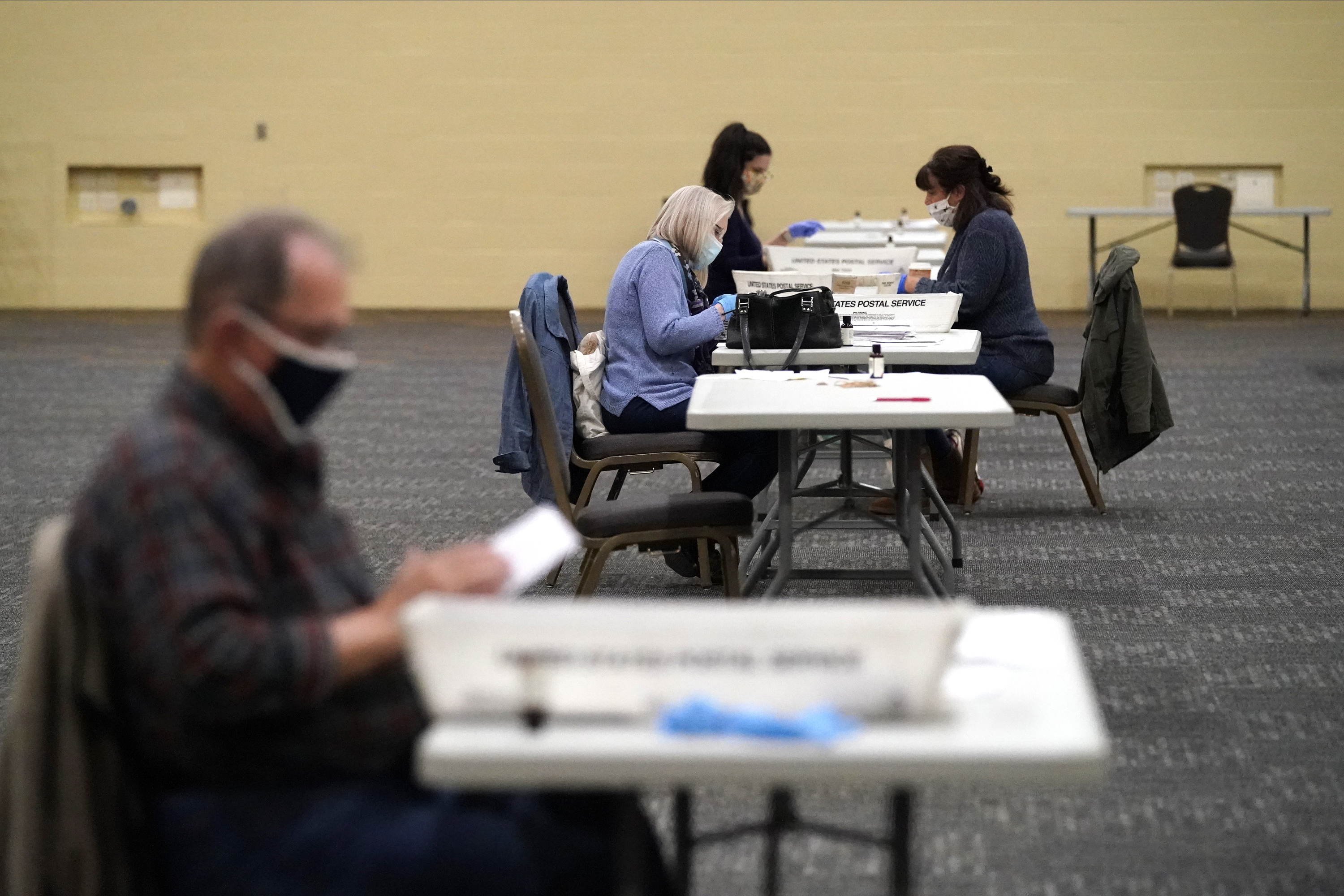 FILE - Workers prepare mail-in ballots for counting, Nov. 4, 2020, at the convention center in Lancaster, Pa. (AP Photo/Julio Cortez, File)