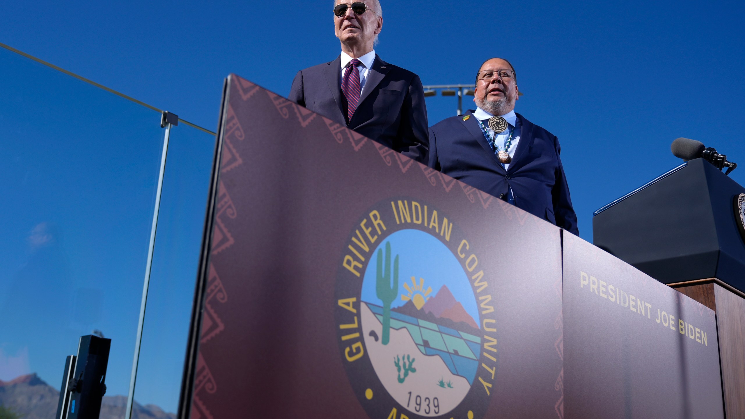 President Joe Biden, left, joined by Stephen Roe Lewis, Governor of the Gila River Indian Community, arrives to speak at the Gila Crossing Community School in the Gila River Indian Community reservation in Laveen, Ariz., Friday, Oct. 25, 2024. (AP Photo/Manuel Balce Ceneta)