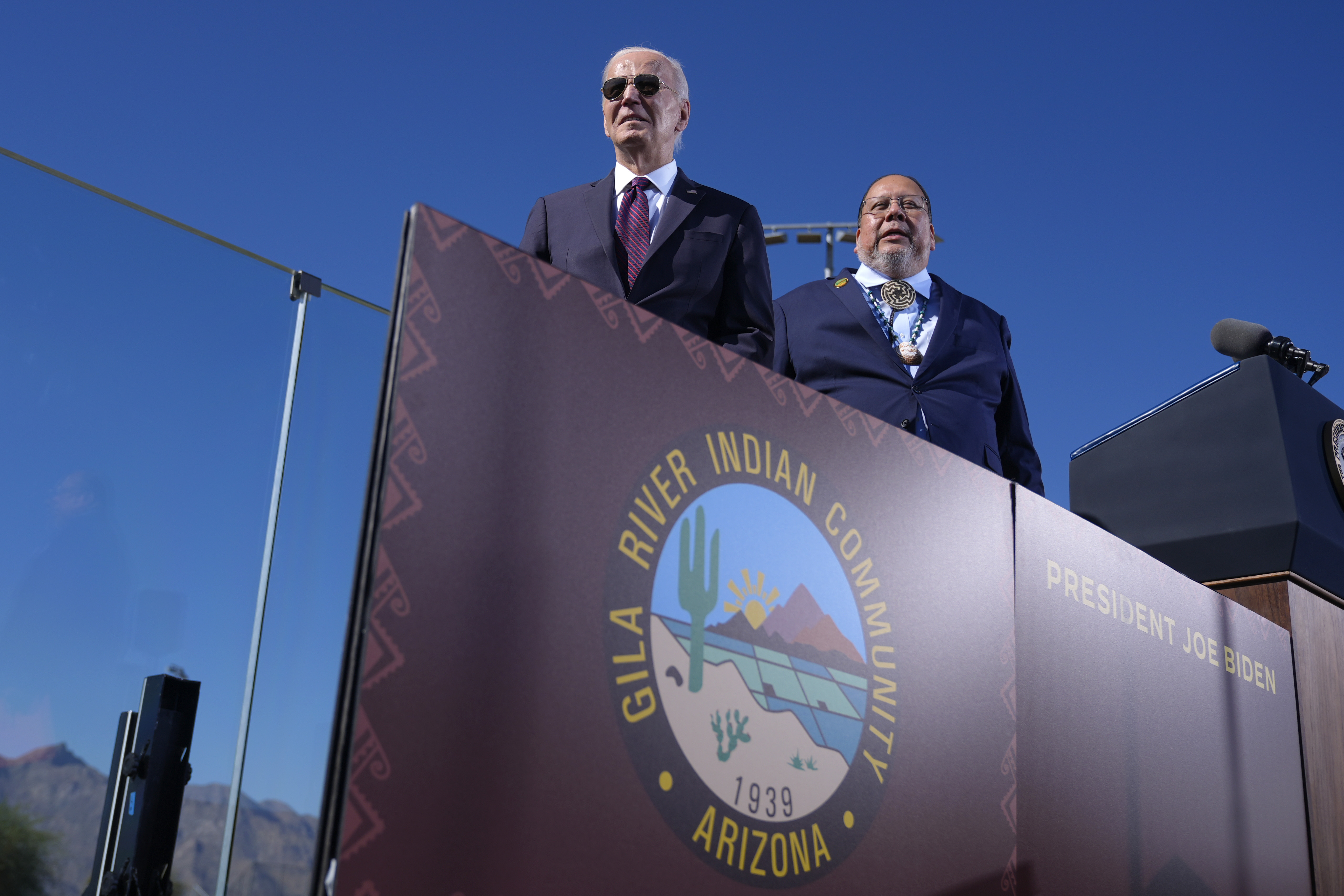 President Joe Biden, left, joined by Stephen Roe Lewis, Governor of the Gila River Indian Community, arrives to speak at the Gila Crossing Community School in the Gila River Indian Community reservation in Laveen, Ariz., Friday, Oct. 25, 2024. (AP Photo/Manuel Balce Ceneta)