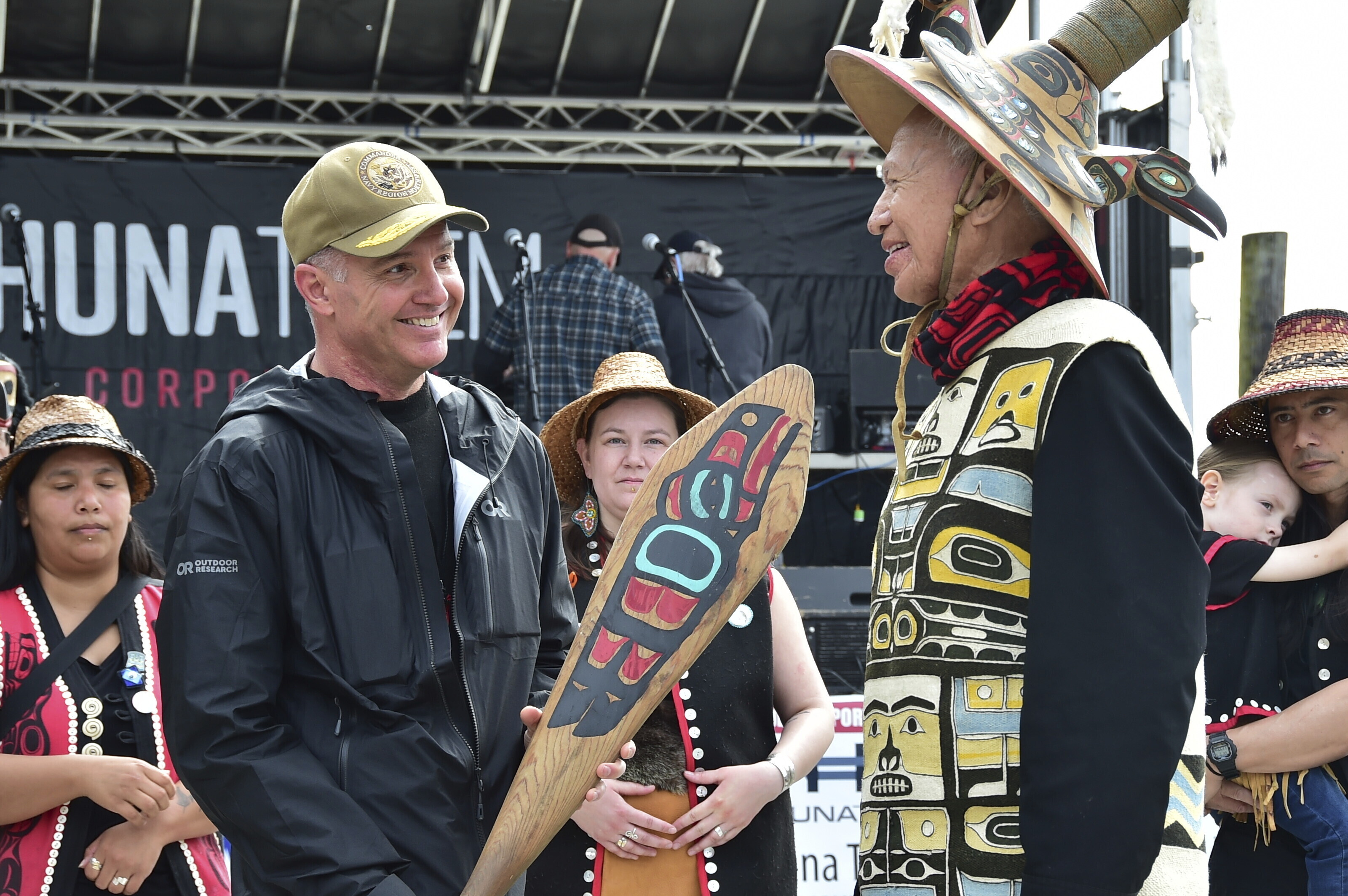 In this photo provided by the U.S. Navy, Commander of Navy Region Northwest Rear Adm. Mark Sucato is gifted a canoe paddle by Leonard John, Raven Clan, Native Village of Angoon, following the One People Canoe Society's welcoming ceremony to kick off the annual Juneau Maritime Festival on May 4, 2024, in Juneau, Alaska. (Chief Mass Communication Spc. Gretchen Albrecht/U.S. Navy via AP)