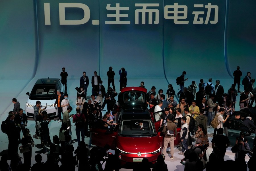 FILE - Attendees take a close look at the Volkswagen ID.7 Vizzion, a new electric flagship sedan during a world premiere on the eve of the Auto Shanghai 2023 show in Shanghai, China, April 17, 2023. (AP Photo/Ng Han Guan, File)