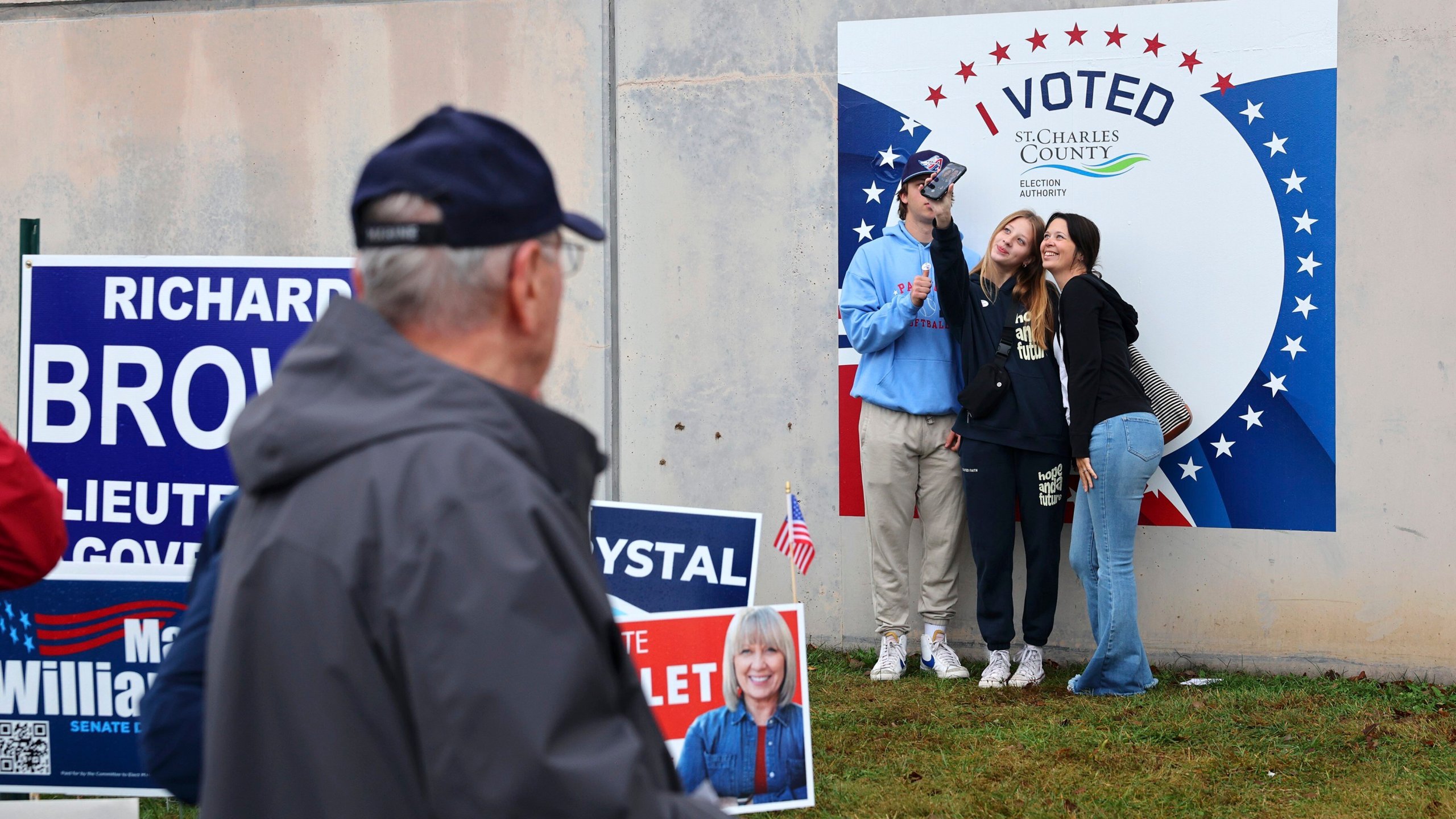 First time voters Efton, left, and Eliza Owens, center, take a selfie with their mother Kourtney Owens outside the St. Charles County Election Authority as early voting continues on Thursday, Oct. 31, 2024 in St. Peters, Mo. (Robert Cohen/St. Louis Post-Dispatch via AP)