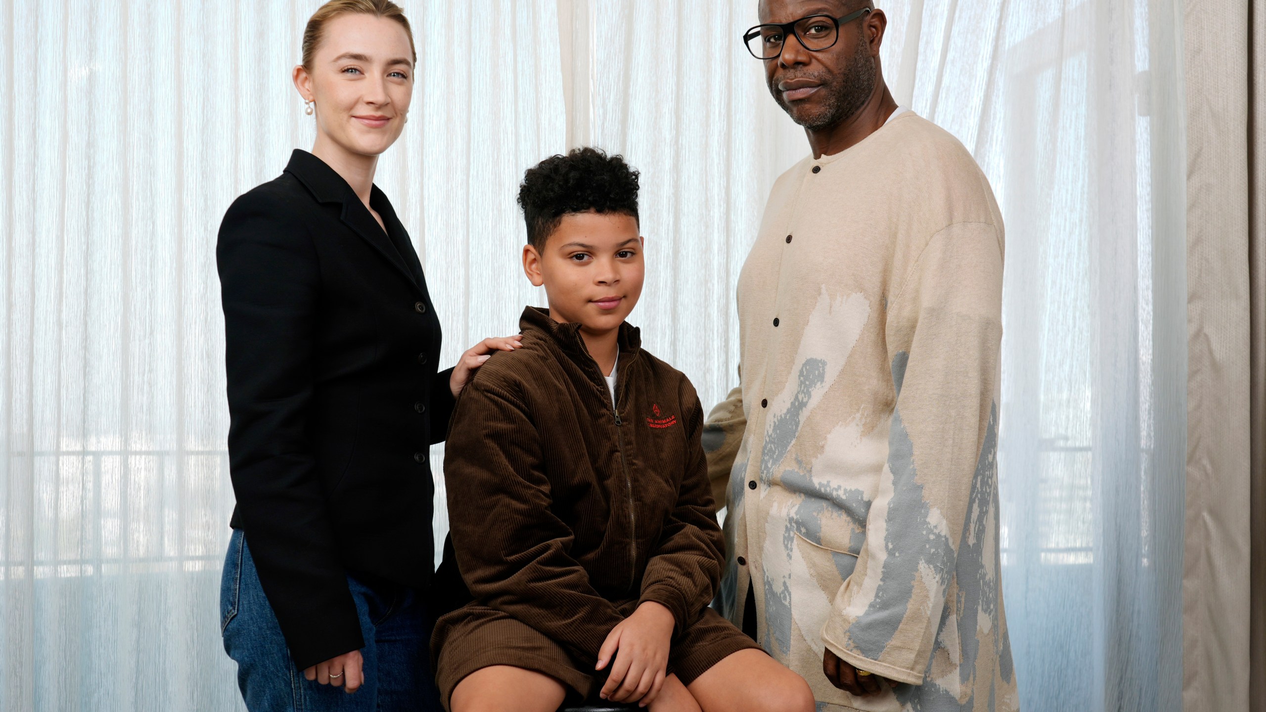 Steve McQueen, right, writer/director of "Blitz," poses with cast members Saoirse Ronan, left, and Elliott Heffernan at the Four Seasons Hotel, Monday, Oct. 14, 2024, in Los Angeles. (AP Photo/Chris Pizzello)