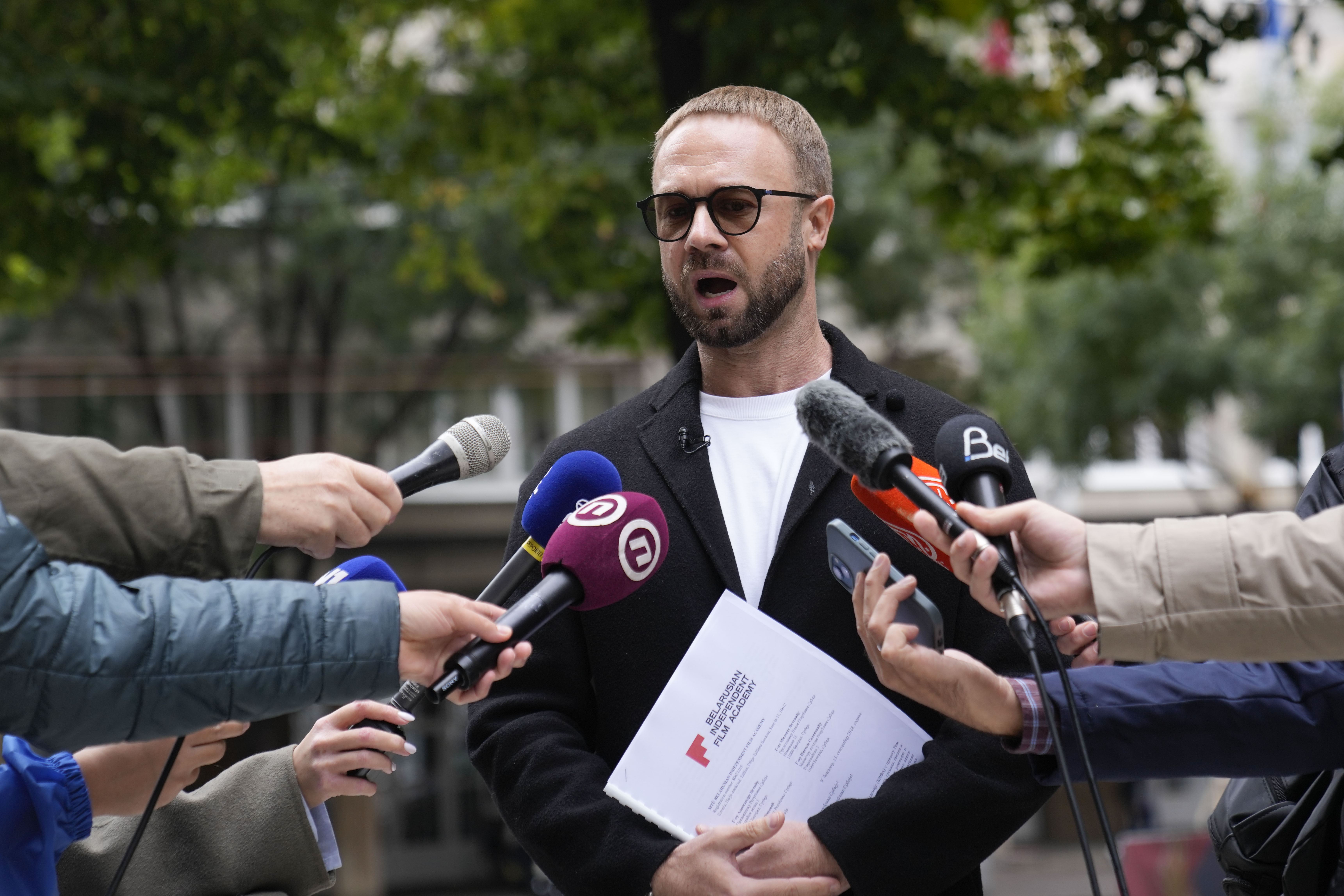 FILE - Prominent critic of the Belarusian government in Minsk, Andrei Hniot, speaks to media in front of the presidency building in Belgrade, Serbia, Monday, Sept. 16, 2024. (AP Photo/Darko Vojinovic, File)