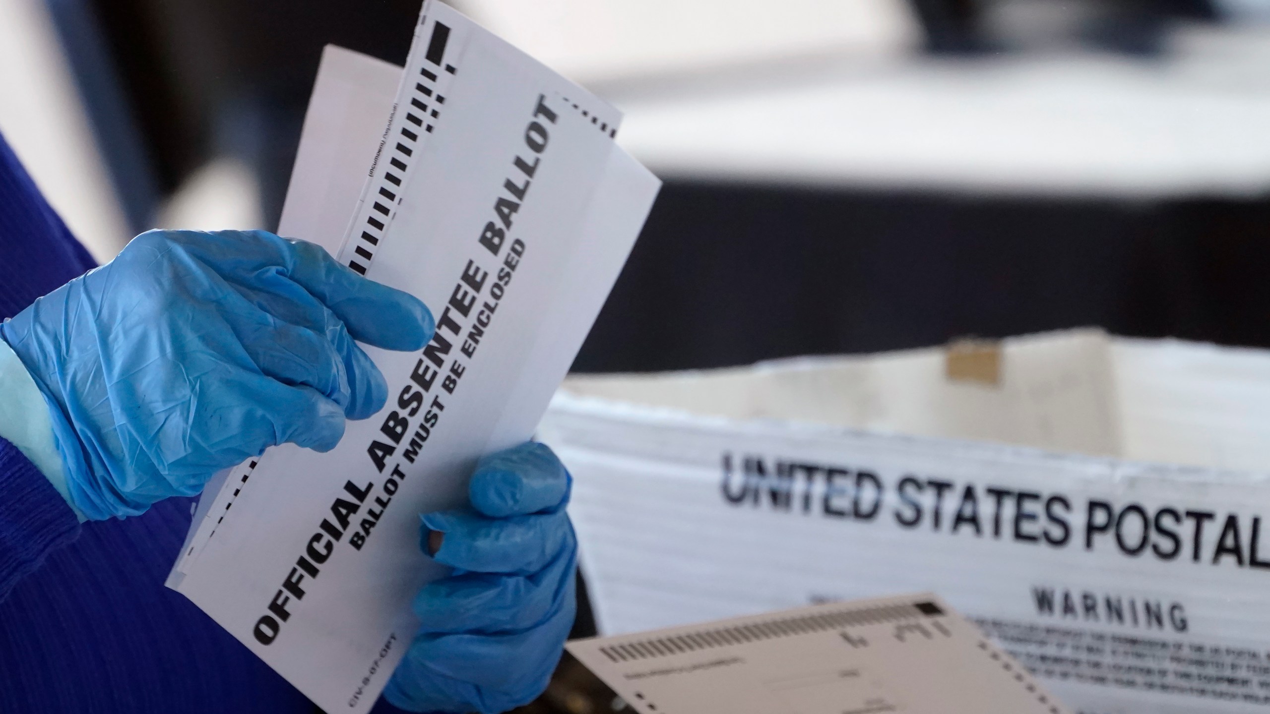 FILE - A worker at the Fulton County Board of Registration and Elections works to process absentee ballots at the State Farm Arena, Nov. 2, 2020, in Atlanta. (AP Photo/John Bazemore, File)