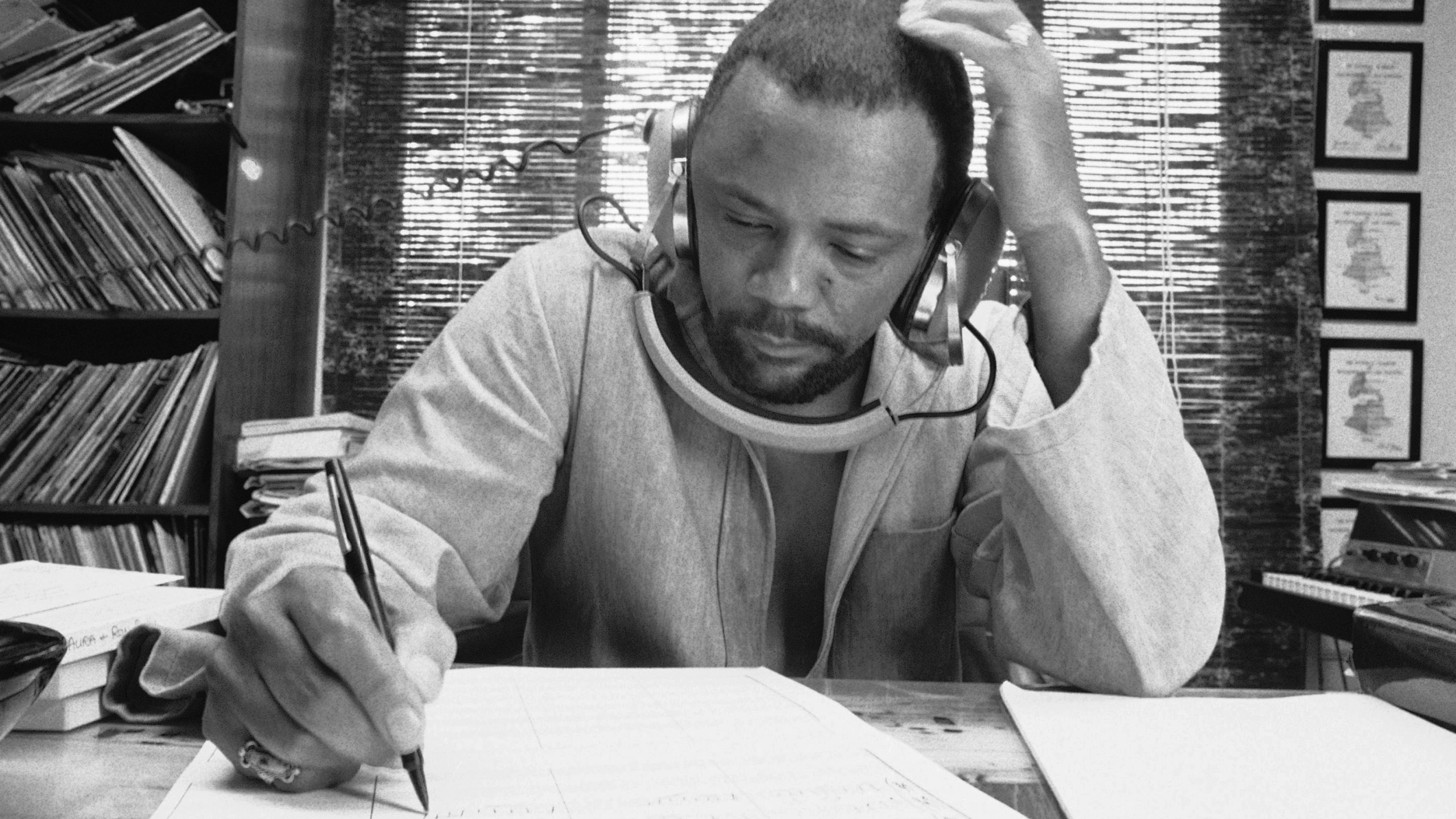 FILE - Composer Quincy Jones at his home studio in October 1974 writing music, listening to a recording on his headphones. (AP Photo/George Brich, File)