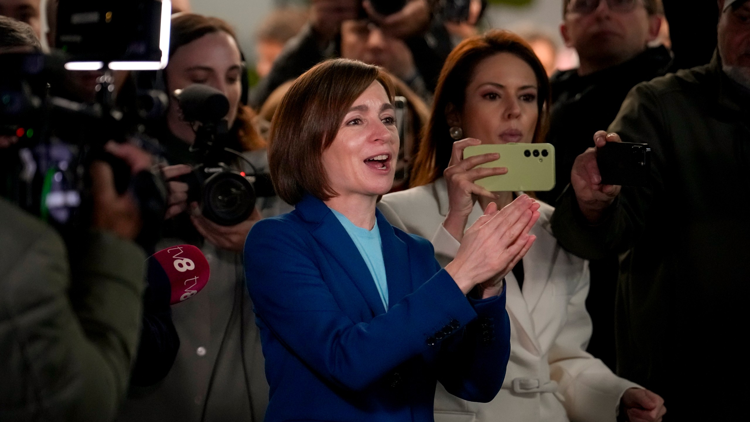 Moldova's President Maia Sandu claps her hands next to media as preliminary results are announced for the presidential election runoff in Chisinau, Moldova, Sunday, Nov. 3, 2024. (AP Photo/Vadim Ghirda)