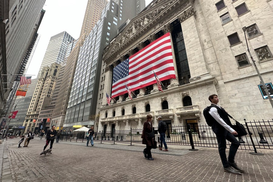 People pass the New York Stock Exchange in New York's Financial District on Tuesday, Nov. 5, 2024. (AP Photo/Peter Morgan)