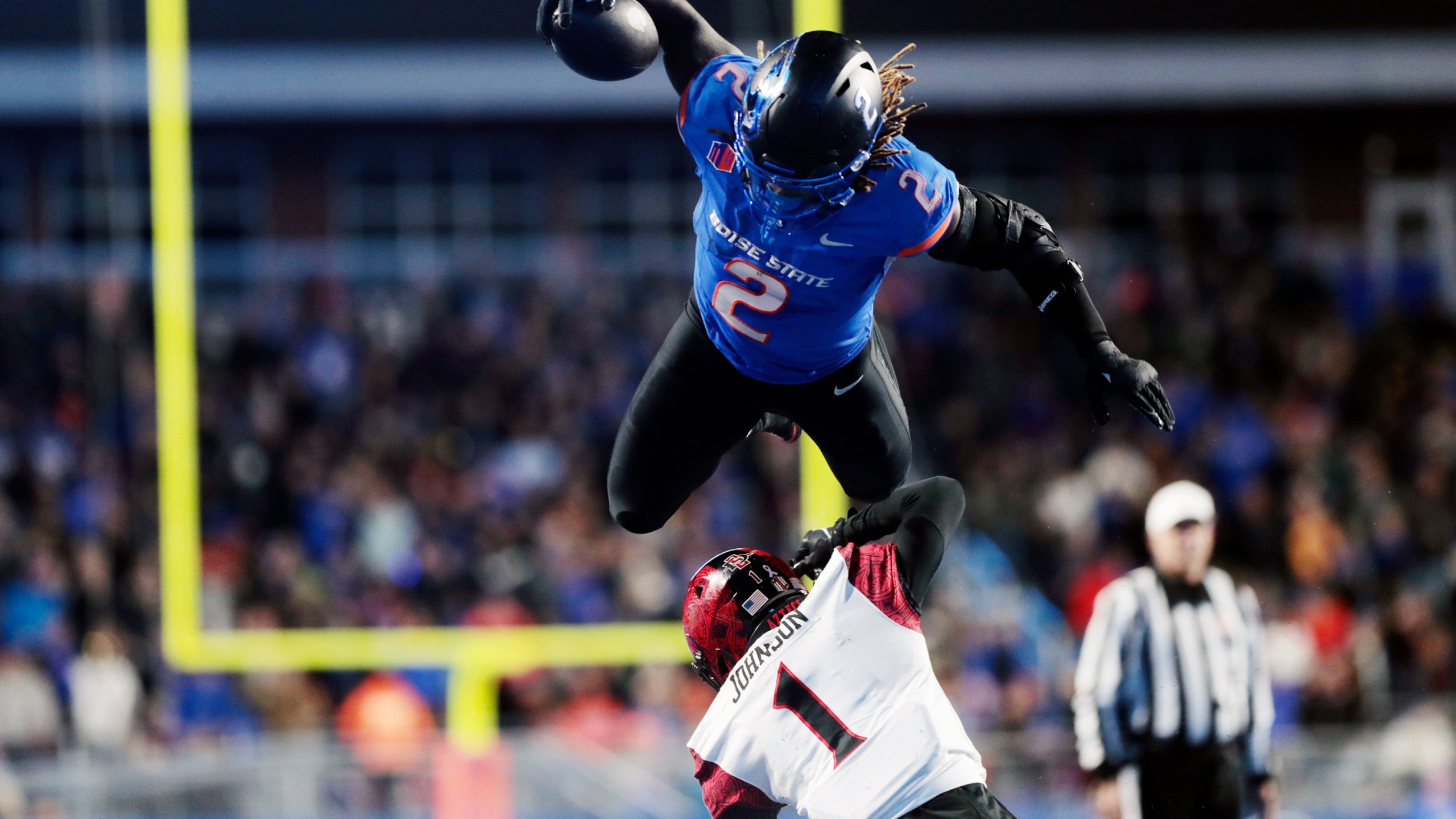 Boise State running back Ashton Jeanty leaps over San Diego State cornerback Chris Johnson during the second half of an NCAA college football game Friday, Nov. 1, 2024, in Boise, Idaho. (Kyle Green/Idaho Statesman via AP)