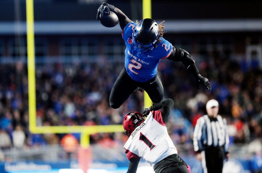 Boise State running back Ashton Jeanty leaps over San Diego State cornerback Chris Johnson during the second half of an NCAA college football game Friday, Nov. 1, 2024, in Boise, Idaho. (Kyle Green/Idaho Statesman via AP)