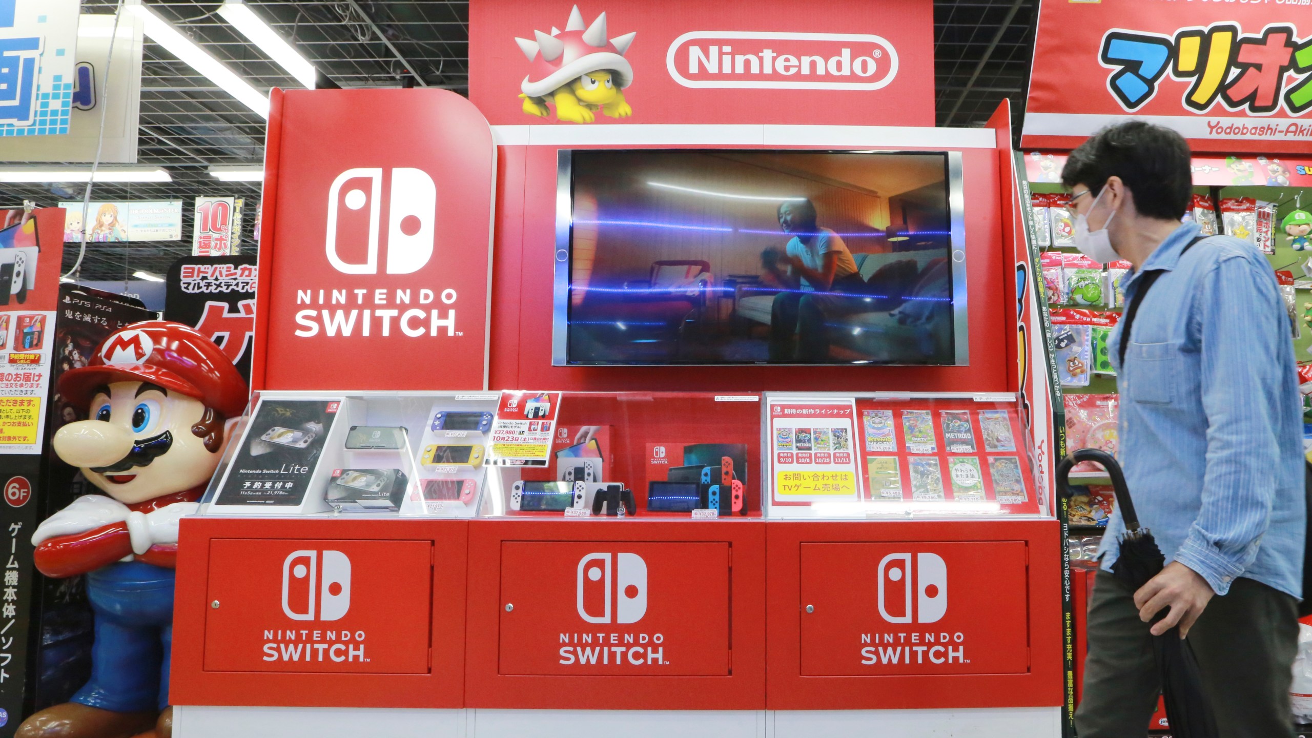 FILE - A man walks by Switch from Nintendo at an electronics retail chain store in Tokyo, on Oct. 13, 2021. (AP Photo/Koji Sasahara, File)