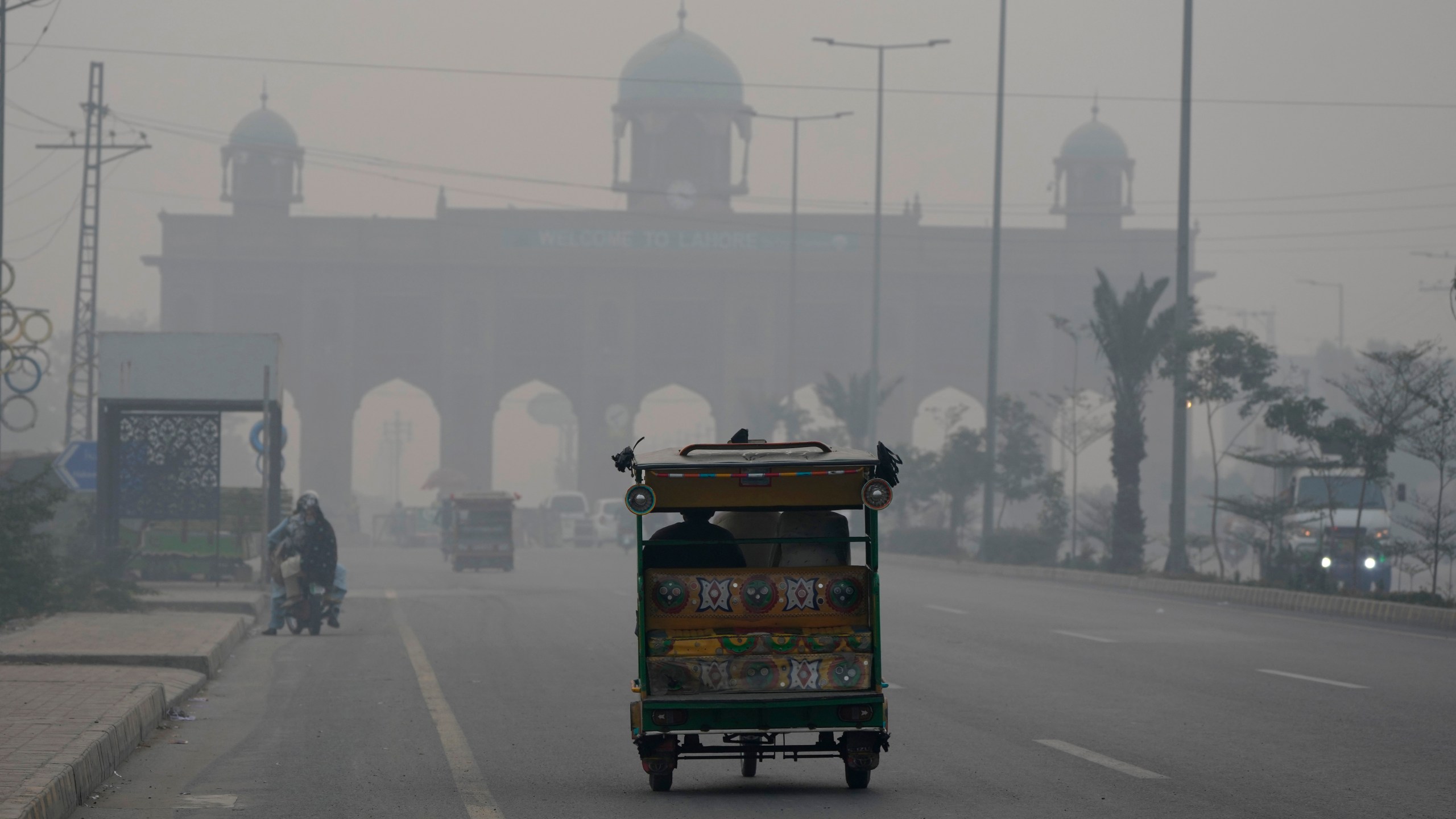 A motorcycle-rickshaw drives on a road as smog envelops the areas of Lahore, Pakistan, Wednesday, Nov. 6, 2024. (AP Photo/K.M. Chaudary)