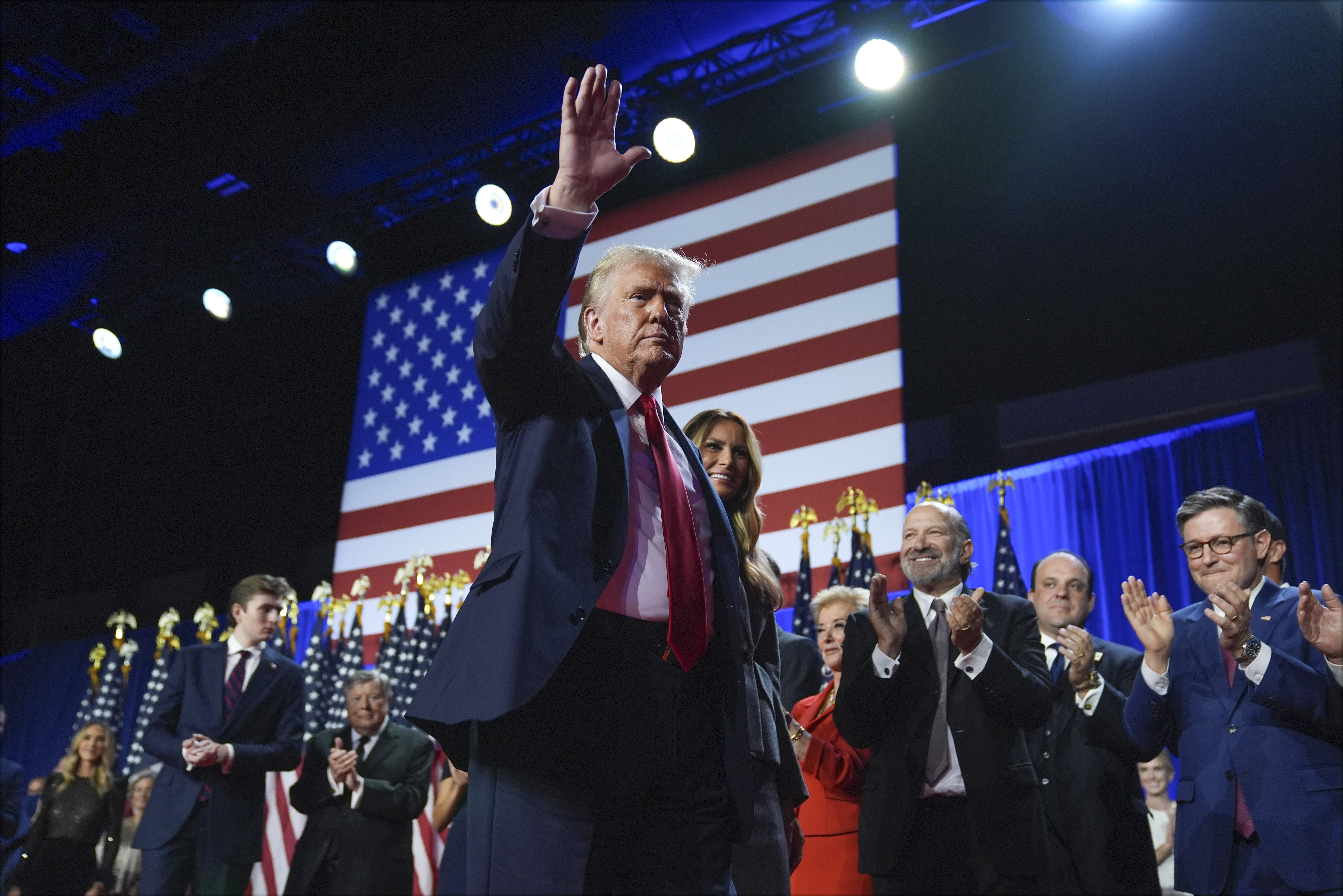 Republican presidential nominee former President Donald Trump waves as he walks with former first lady Melania Trump at an election night watch party at the Palm Beach Convention Center, Wednesday, Nov. 6, 2024, in West Palm Beach, Fla. (AP Photo/Evan Vucci)