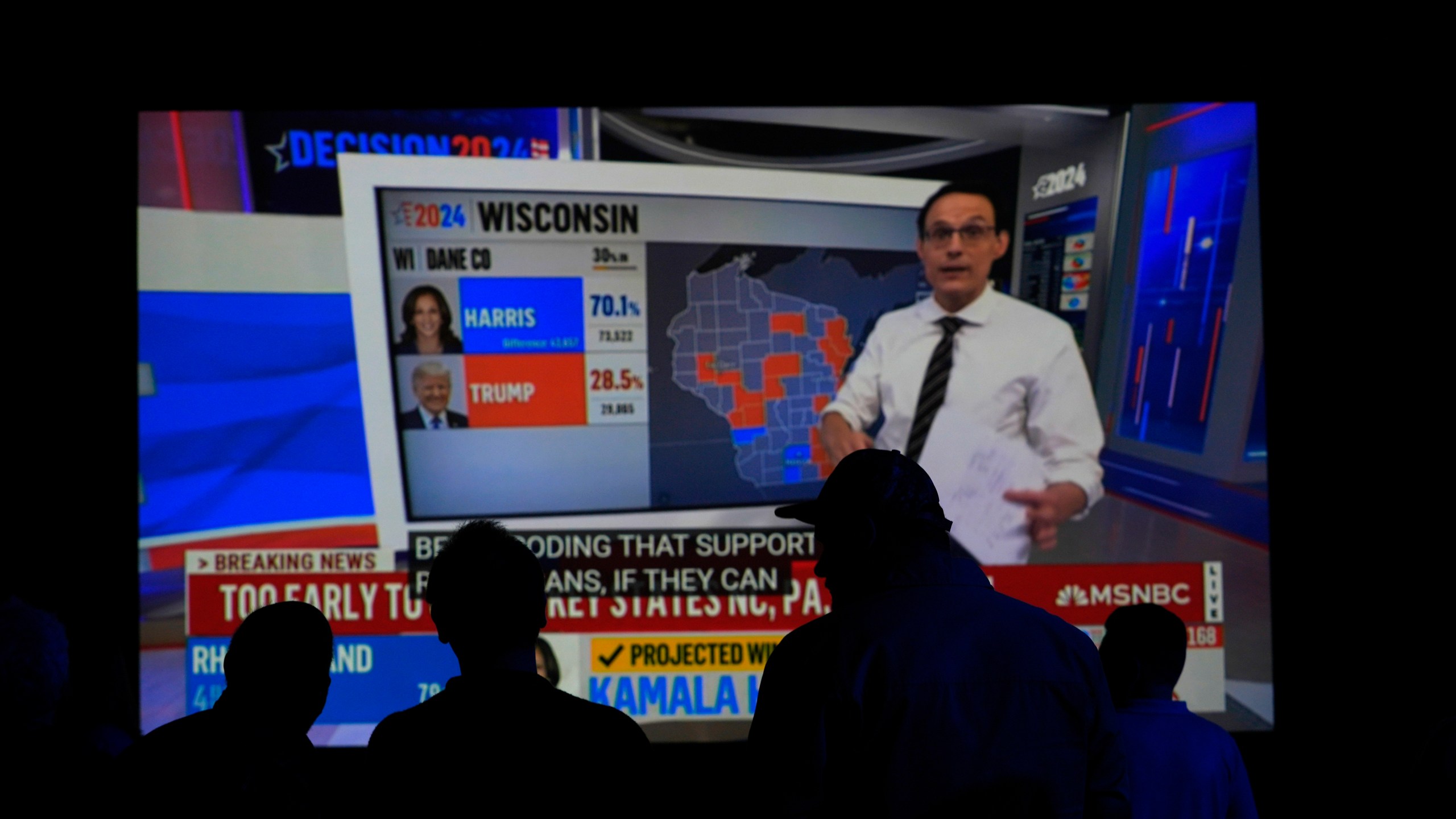 People watch results come in on a television screen at the DFL electionnight party, Tuesday, Nov. 5, 2024, in St. Paul, Minn. (AP Photo/Abbie Parr)