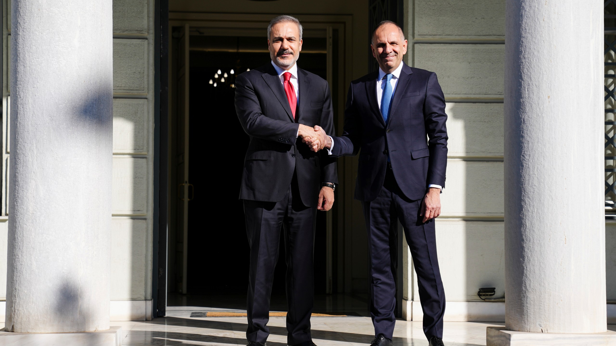 Greek Foreign Minister George Gerapetritis, right, welcomes his Turkish counterpart Hakan Fidan before their meeting in Athens, Greece, Friday, Nov. 8, 2024. (AP Photo/Thanassis Stavrakis)