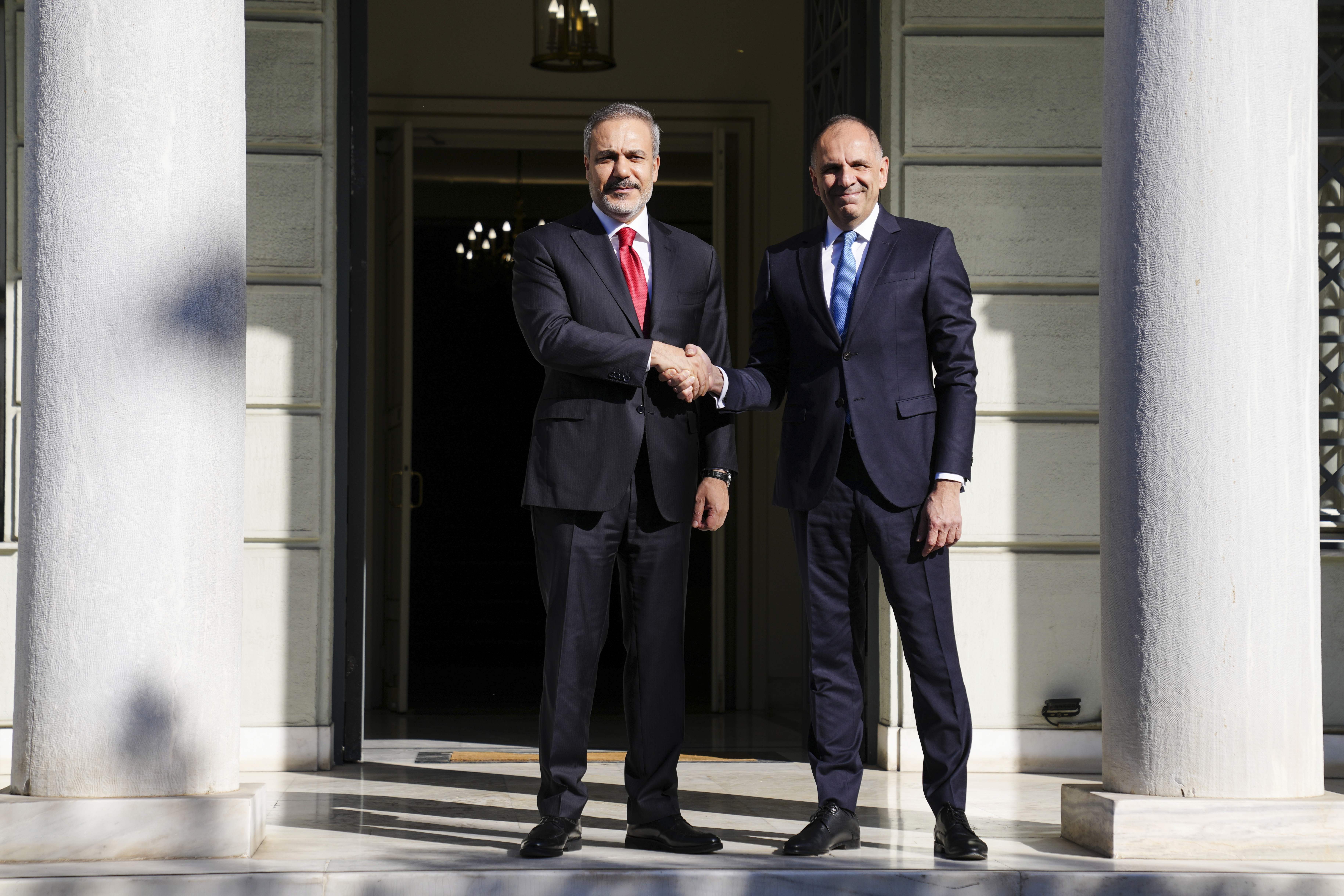 Greek Foreign Minister George Gerapetritis, right, welcomes his Turkish counterpart Hakan Fidan before their meeting in Athens, Greece, Friday, Nov. 8, 2024. (AP Photo/Thanassis Stavrakis)