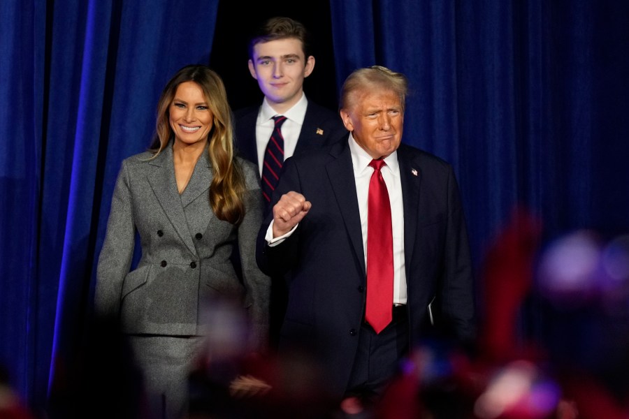 Republican presidential nominee former President Donald Trump, joined by Melania Trump, left, and Barron Trump, arrives to speak at an election night watch party, Wednesday, Nov. 6, 2024, in West Palm Beach, Fla. (AP Photo/Alex Brandon)