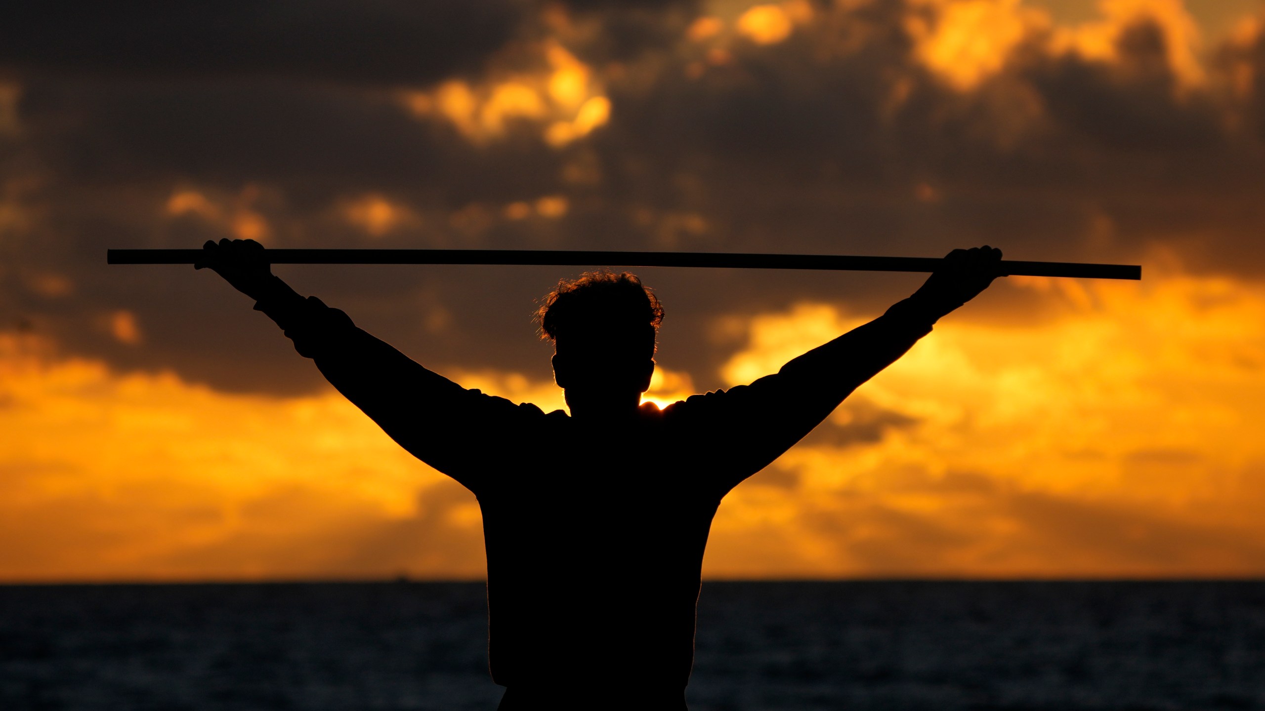 FILE - A beach goer exercises as the sun rises above the Atlantic Ocean, Feb. 1, 2023, in Surfside, Fla. (AP Photo/Wilfredo Lee, File)