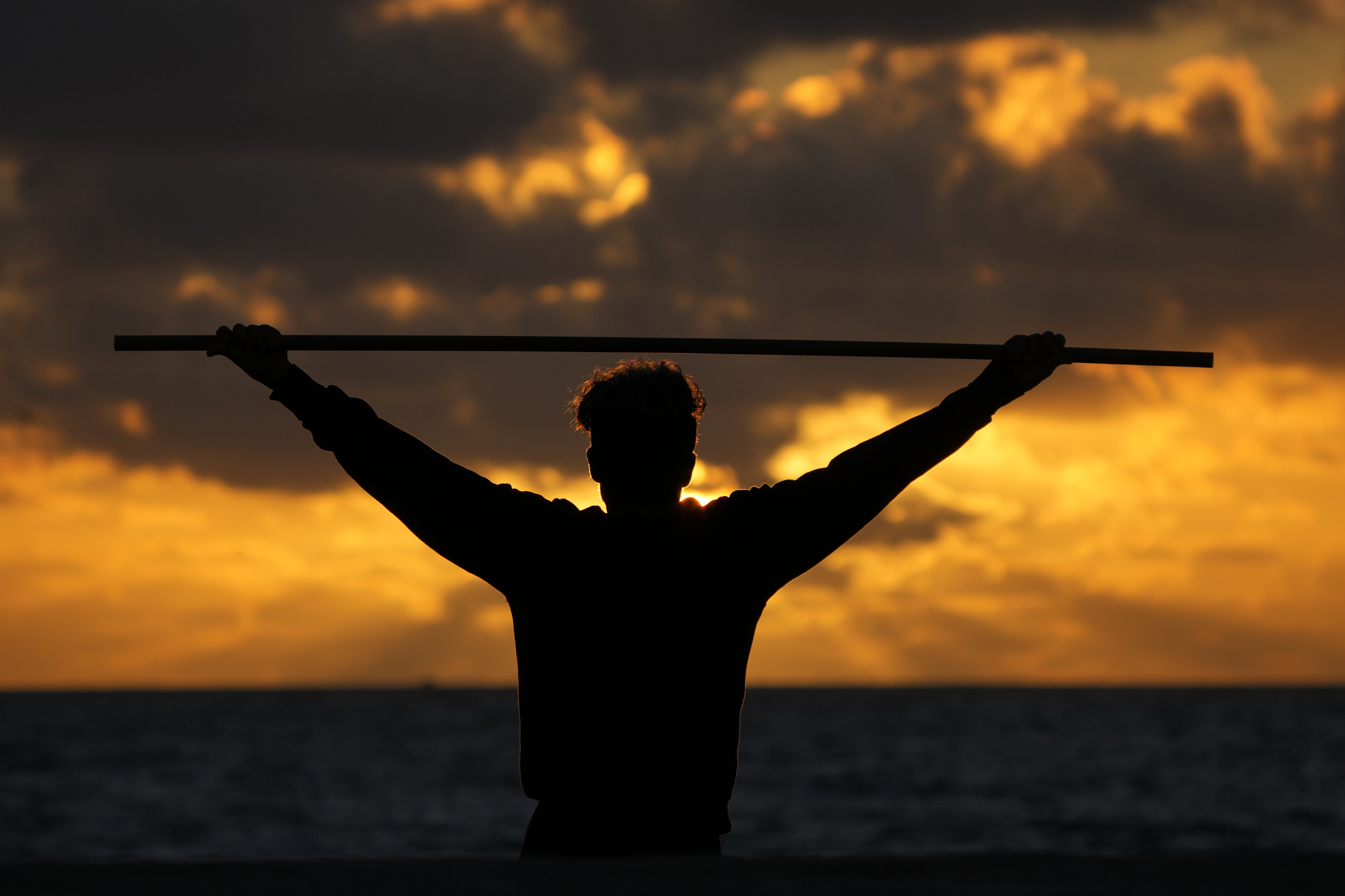 FILE - A beach goer exercises as the sun rises above the Atlantic Ocean, Feb. 1, 2023, in Surfside, Fla. (AP Photo/Wilfredo Lee, File)