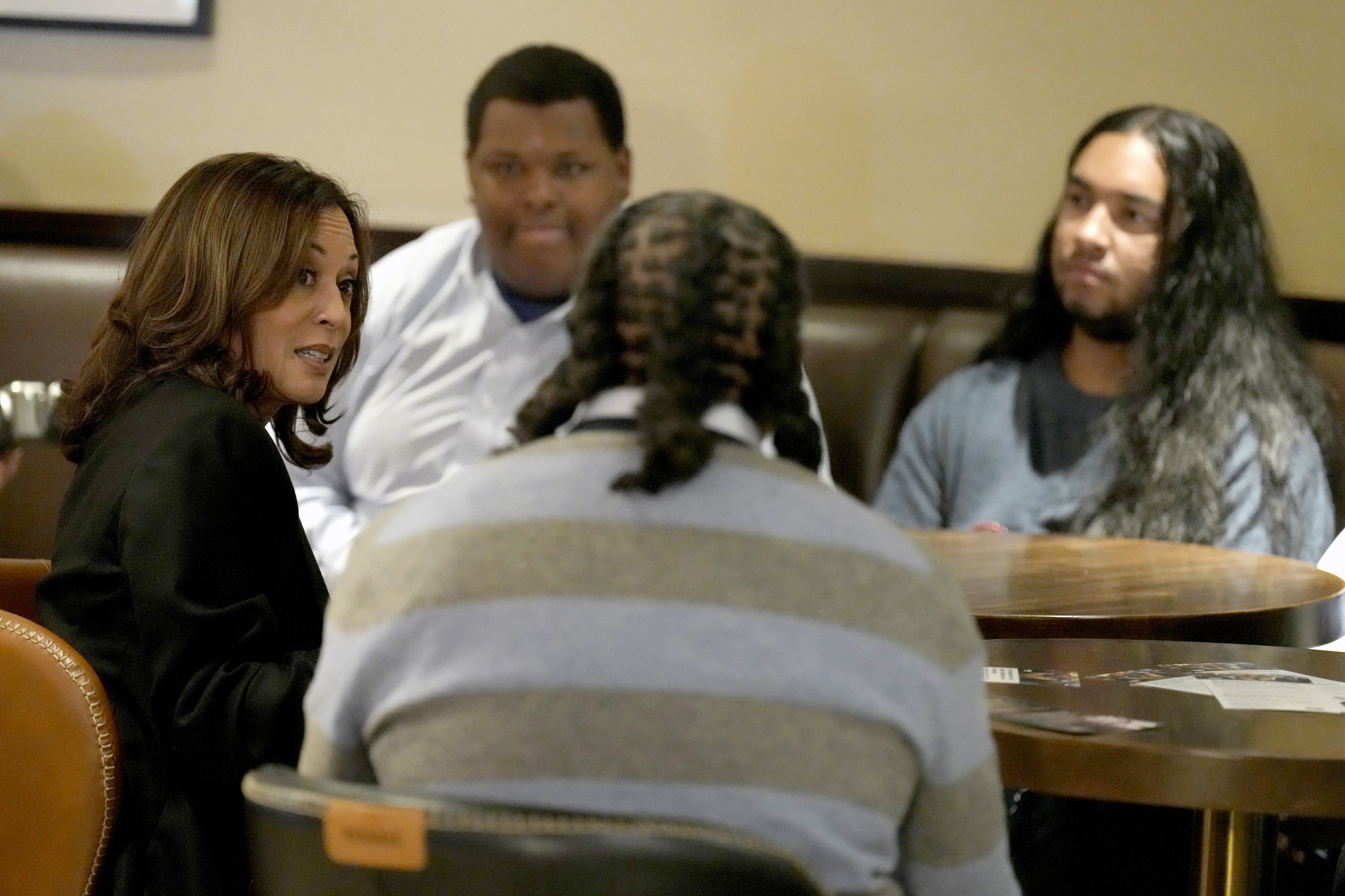 FILE - Democratic presidential nominee Vice President Kamala Harris, left, participates in a roundtable discussion with Black men during a visit to Legenderie Records and Coffee House, a Black-owned small business in Erie, Pa., Oct. 14, 2024. (AP Photo/Jacquelyn Martin, File)