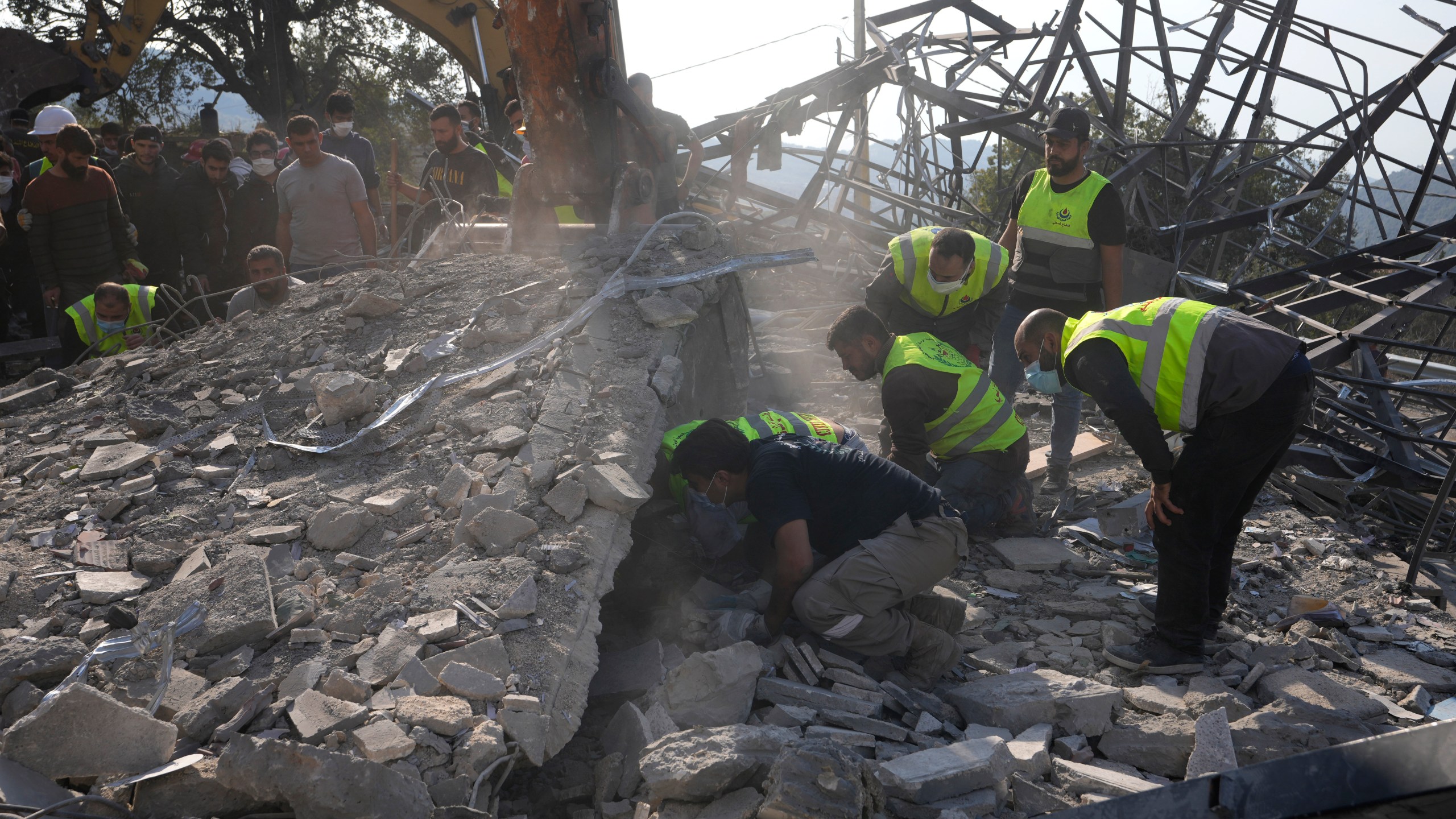 Rescue workers search for victims under the rubble of a destroyed house hit in an Israeli airstrike, in Aalmat village, northern Lebanon, Sunday, Nov. 10, 2024. (AP Photo/Hassan Ammar)