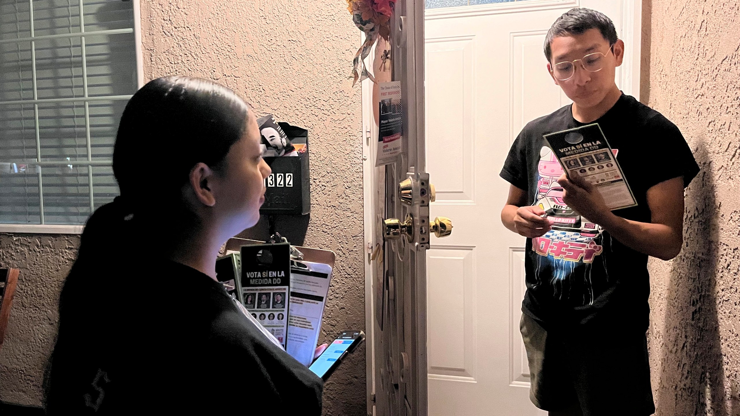 FILE - Genesis Lopez, 21, speaks with Santa Ana, Calif. resident Eduardo Entimio, 23, on Wednesday, Oct. 23, 2024, about Measure DD, which would allow noncitizens to vote in local elections. (AP Photo/Jaimie Ding, File)