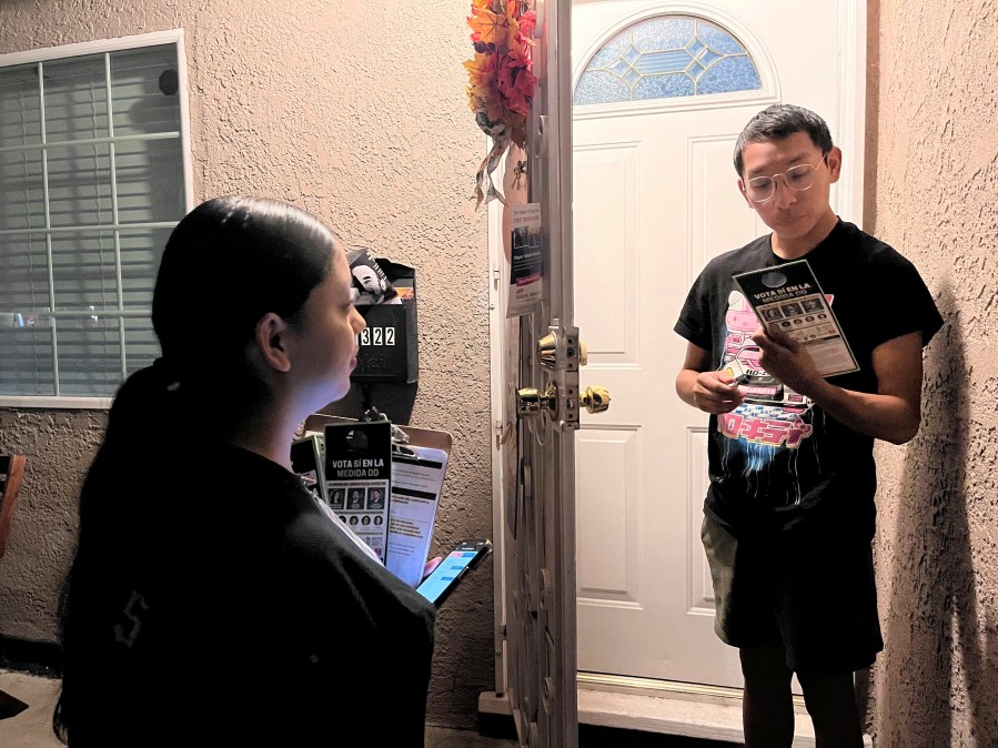 FILE - Genesis Lopez, 21, speaks with Santa Ana, Calif. resident Eduardo Entimio, 23, on Wednesday, Oct. 23, 2024, about Measure DD, which would allow noncitizens to vote in local elections. (AP Photo/Jaimie Ding, File)