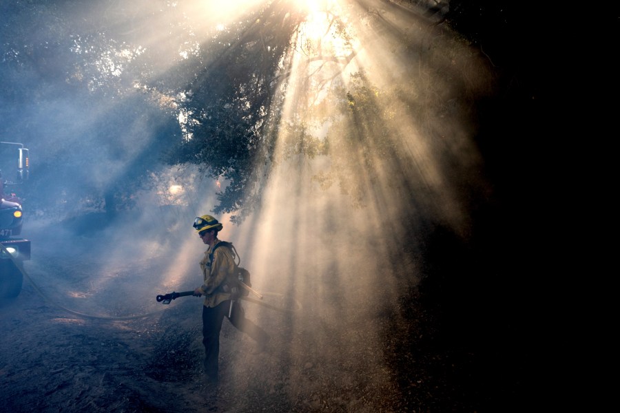 FILE - A firefighter walks through smoke while battling the Mountain Fire, Nov. 7, 2024, in Santa Paula, Calif. (AP Photo/Noah Berger,File)