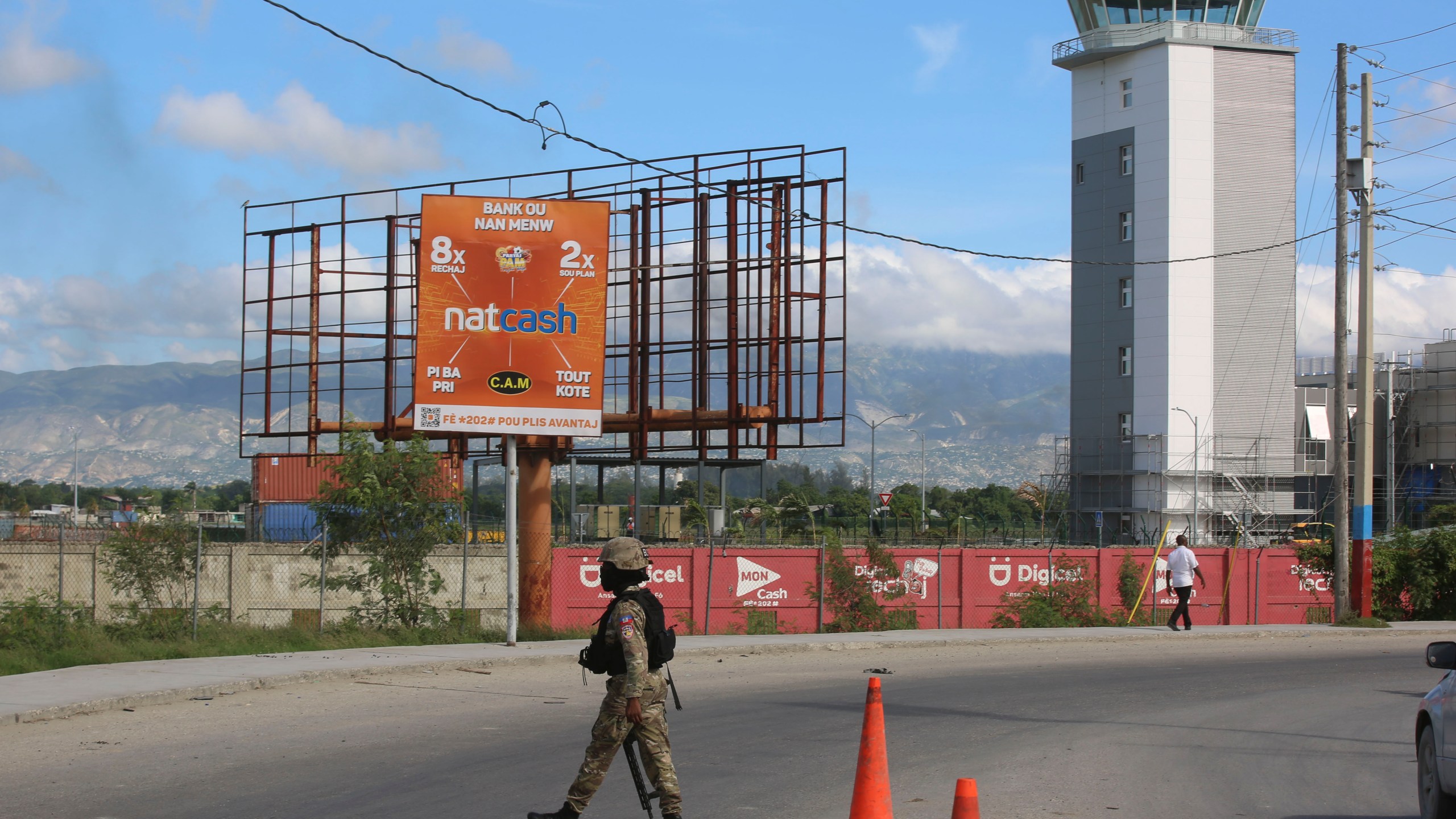 A police officer patrols the entrance of the Toussaint Louverture International Airport, in Port-au-Prince, Haiti, Tuesday, Nov. 12, 2024. (AP Photo/Odelyn Joseph)