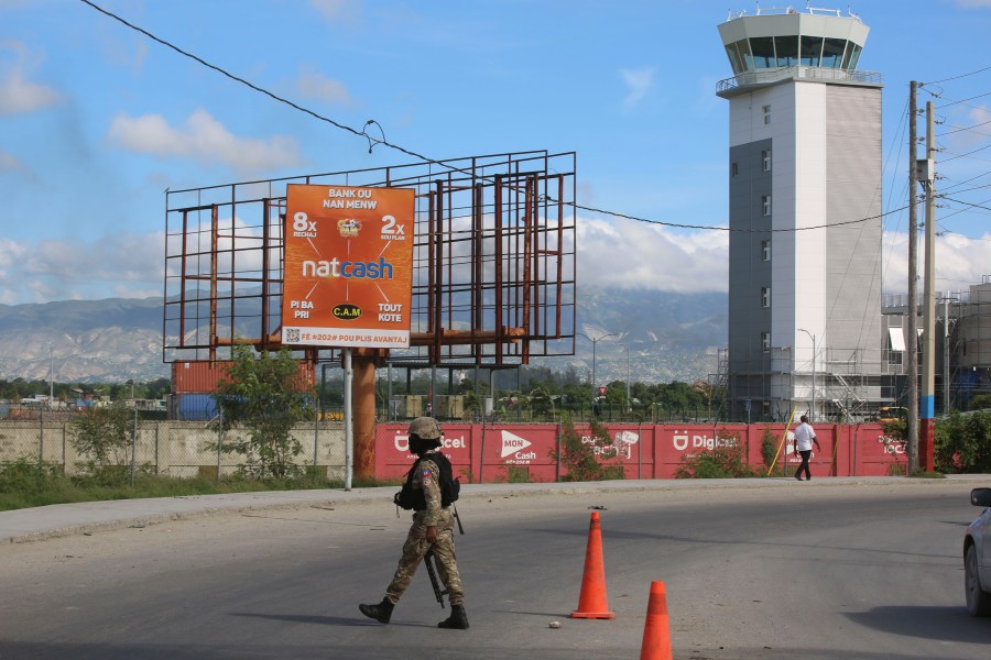 A police officer patrols the entrance of the Toussaint Louverture International Airport, in Port-au-Prince, Haiti, Tuesday, Nov. 12, 2024. (AP Photo/Odelyn Joseph)