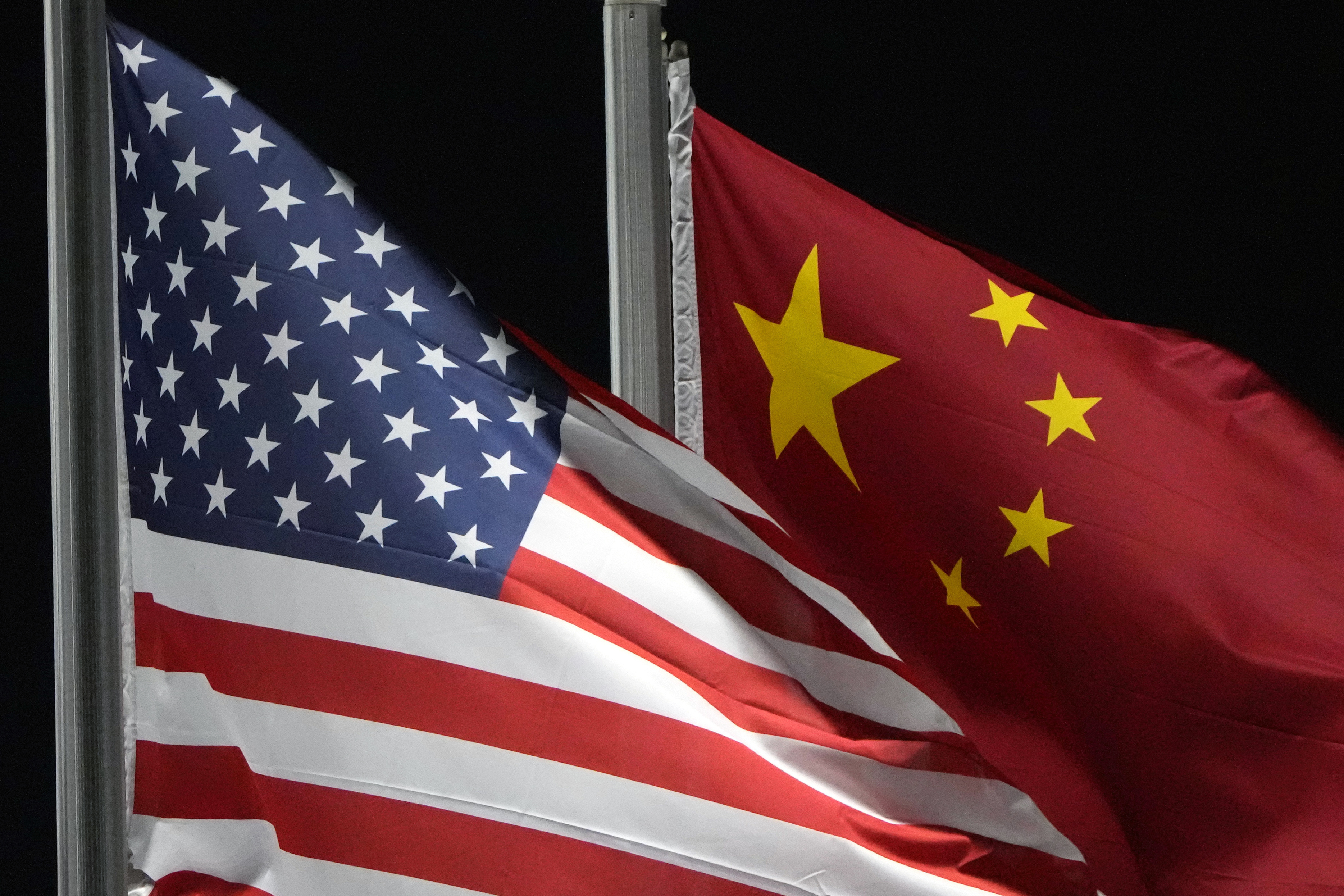 FILE - The American and Chinese flags wave at Genting Snow Park, Feb. 2, 2022, in Zhangjiakou, China. (AP Photo/Kiichiro Sato, File)