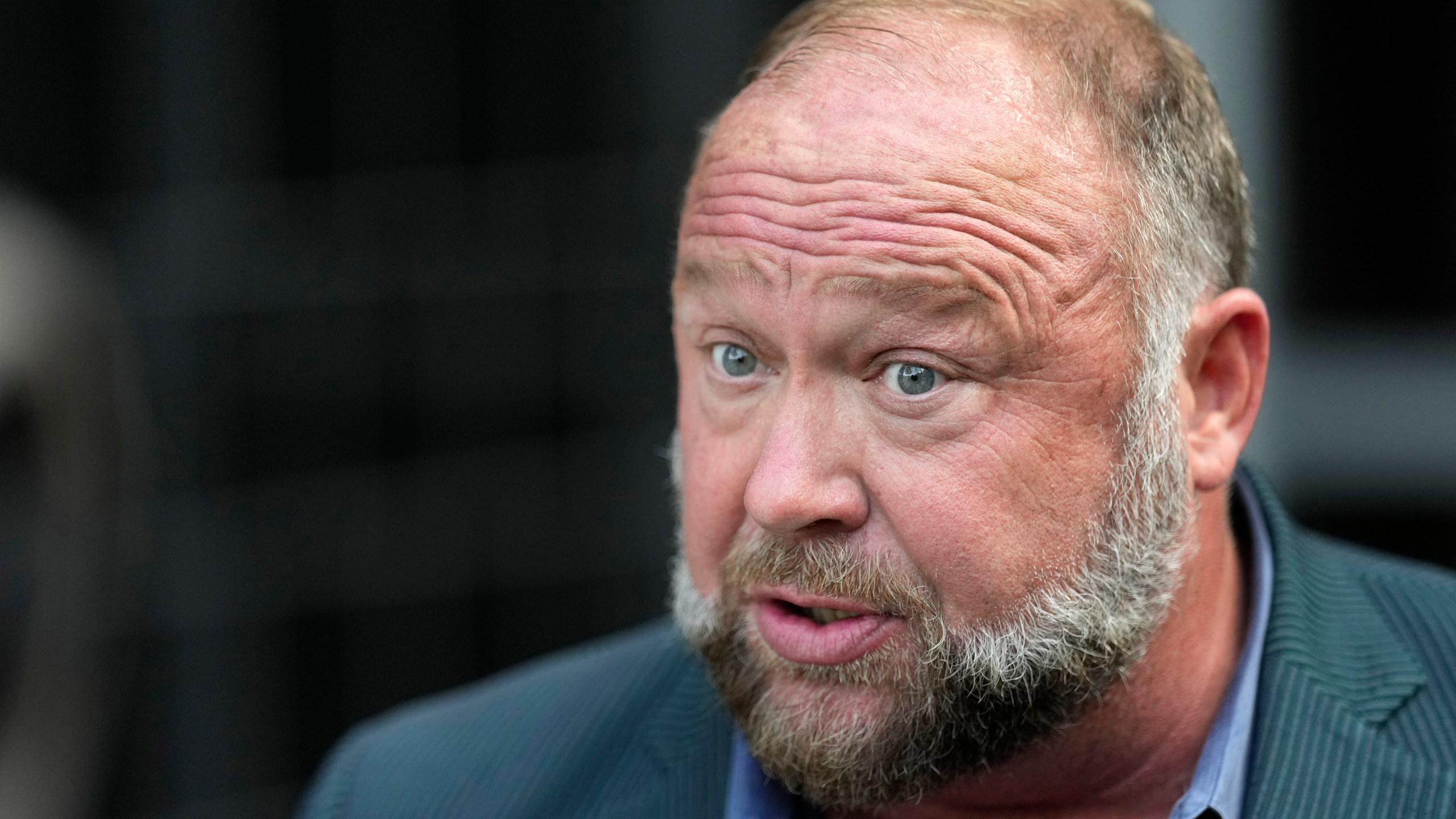 FILE - Right-wing conspiracy theorist Alex Jones speaks to the media after arriving at the federal courthouse for a hearing in front of a bankruptcy judge Friday, June 14, 2024, in Houston. (AP Photo/David J. Phillip, File)