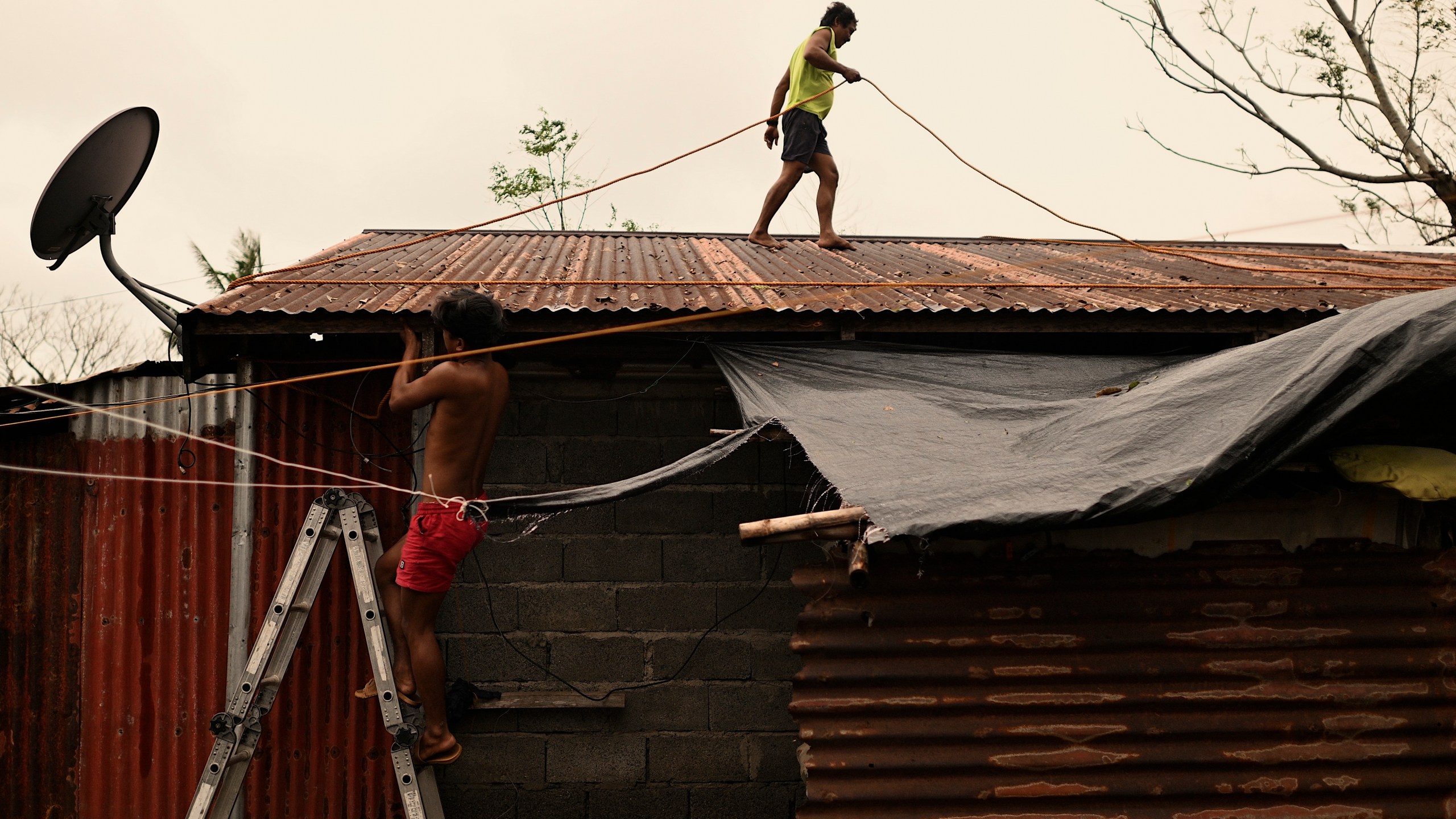 A resident reinforces his roof in Santa Ana, Cagayan Province, northern Philippines as they anticipate Typhoon Usagi to hit their area Thursday, Nov. 14, 2024. (AP Photo/Noel Celis)