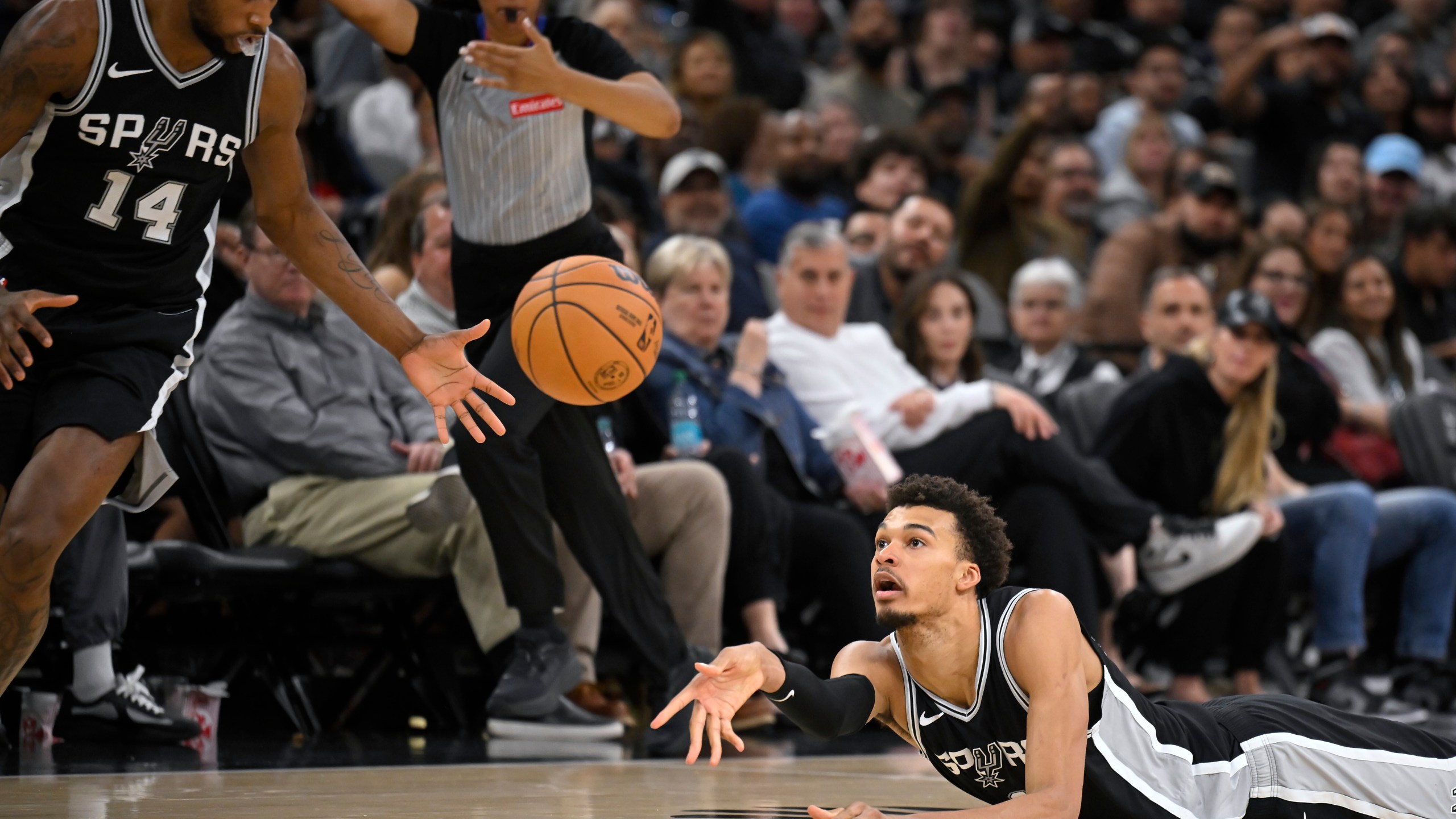 San Antonio Spurs forward Victor Wembanyama, right, passes to Spurs guard Blake Wesley during the second half of their NBA basketball game against the Washington Wizards, Wednesday, Nov. 13, 2024, in San Antonio. San Antonio won 139-130. (AP Photo/Darren Abate)