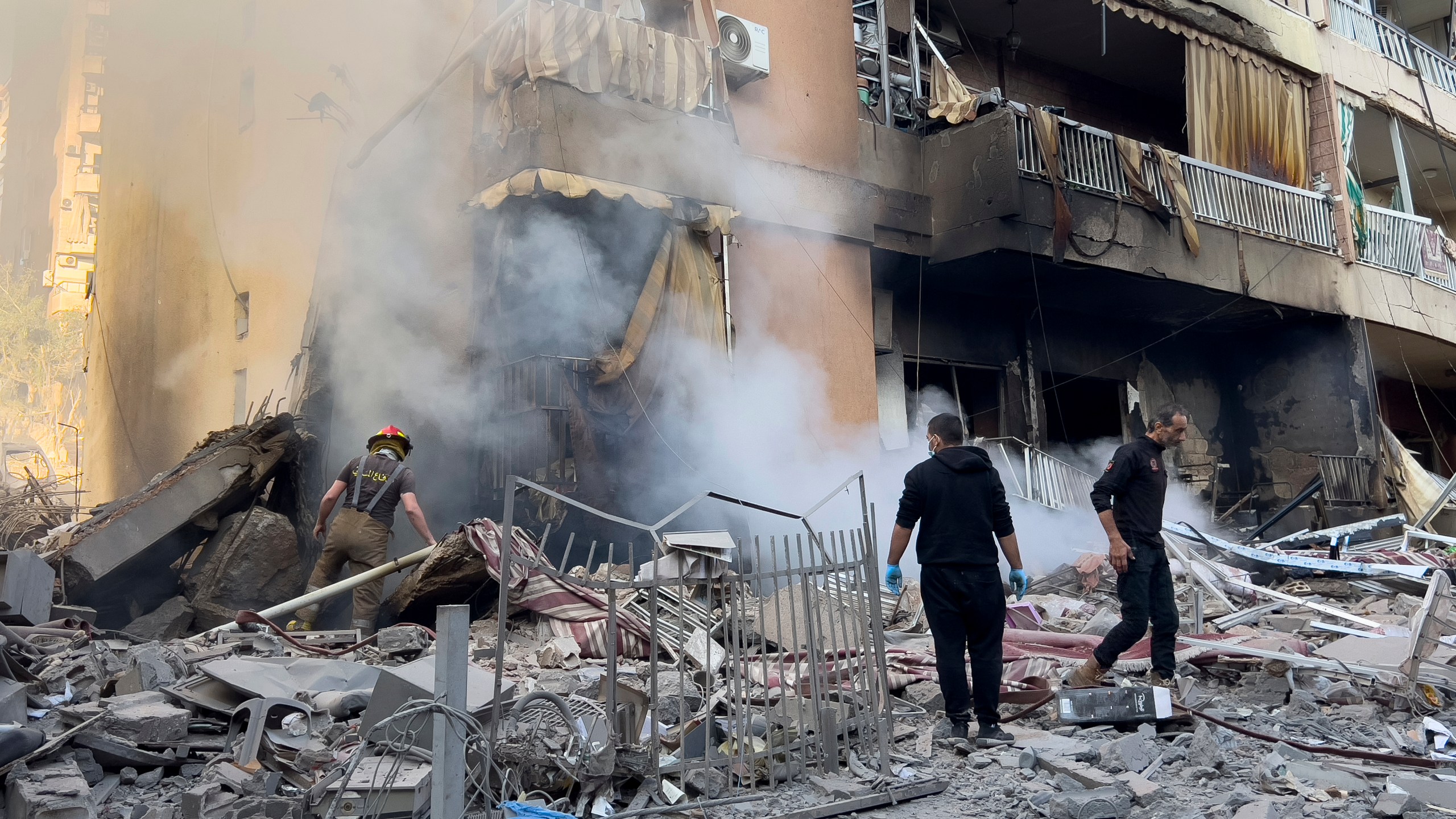 Firefighters check a destroyed building that was hit in an Israeli airstrike in Dahiyeh, in the southern suburb of Beirut, Lebanon, Thursday, Nov. 14, 2024. (AP Photo/Hussein Malla)