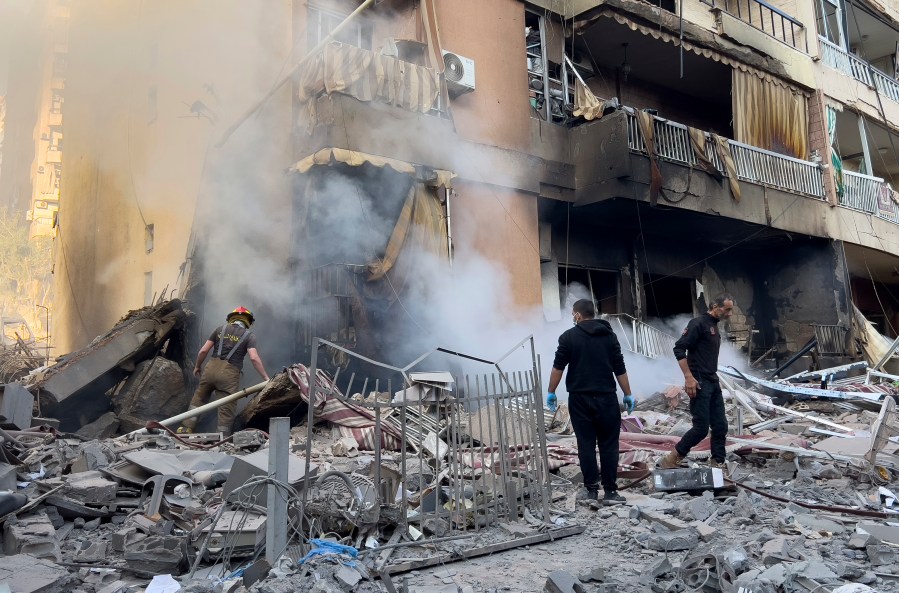 Firefighters check a destroyed building that was hit in an Israeli airstrike in Dahiyeh, in the southern suburb of Beirut, Lebanon, Thursday, Nov. 14, 2024. (AP Photo/Hussein Malla)