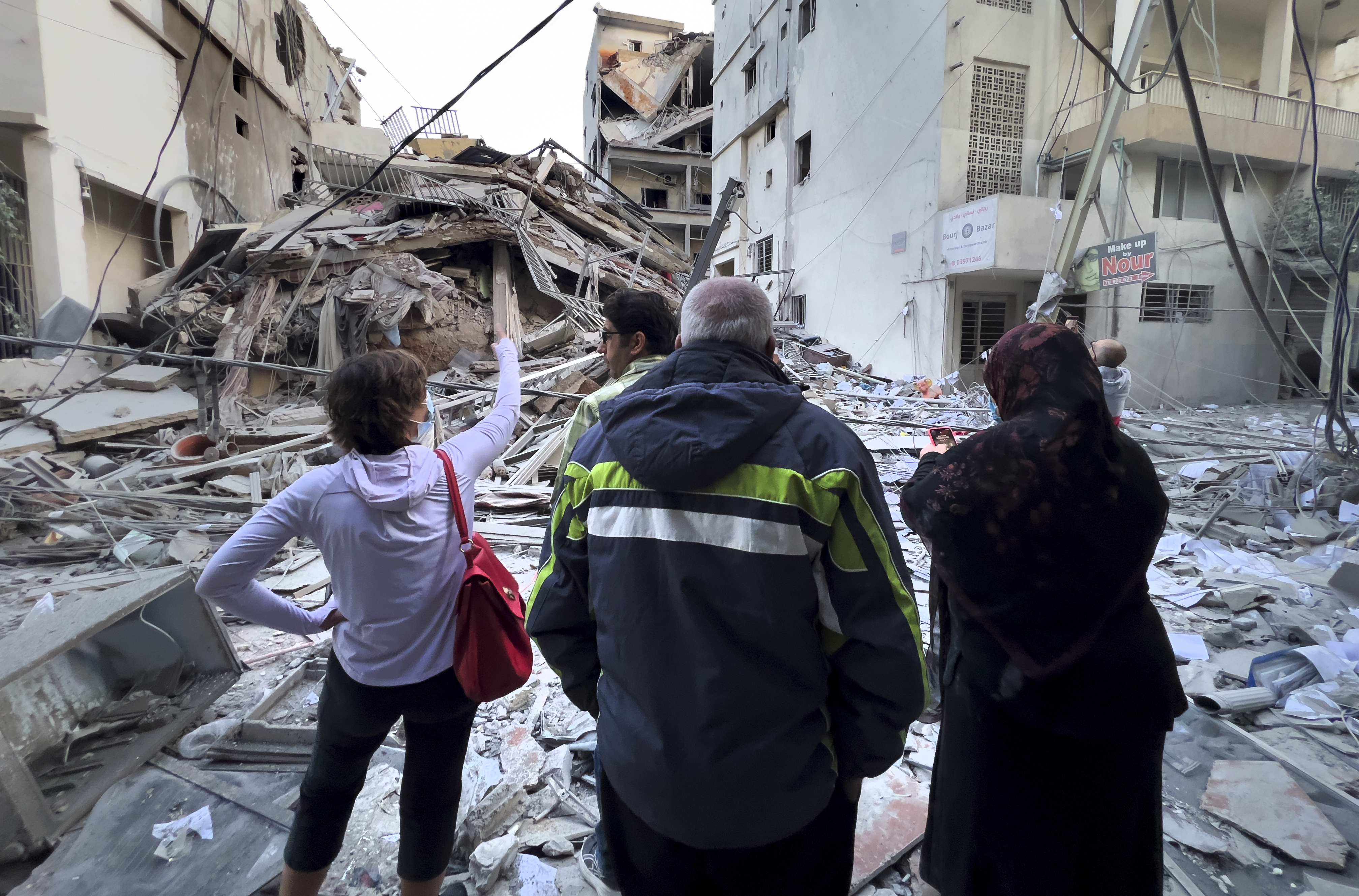 Residents check their destroyed building hit in an Israeli airstrike in Dahiyeh, in the southern suburb of Beirut, Lebanon, Thursday, Nov. 14, 2024. (AP Photo/Hussein Malla)