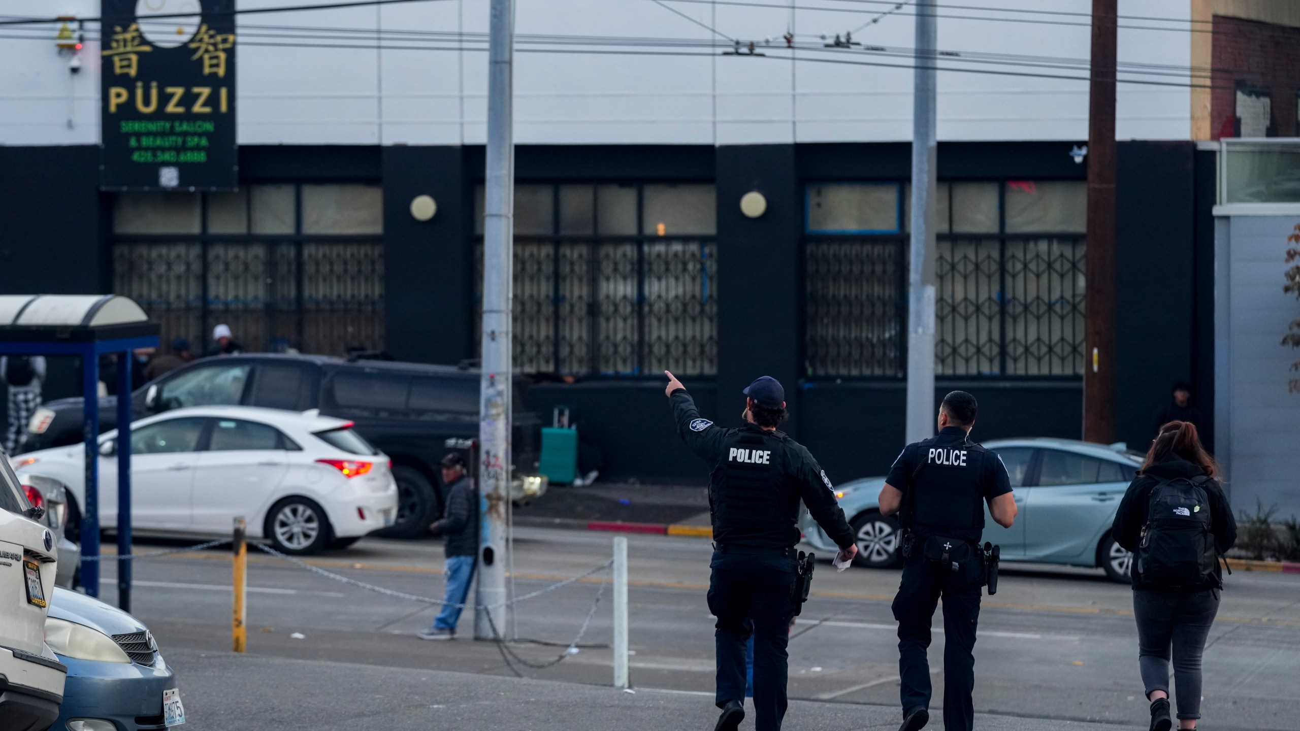 Police officers stand near the scene as they gather security camera footage after multiple people were stabbed in the area Friday, Nov. 8, 2024, in the Chinatown-International District in Seattle. (AP Photo/Lindsey Wasson)