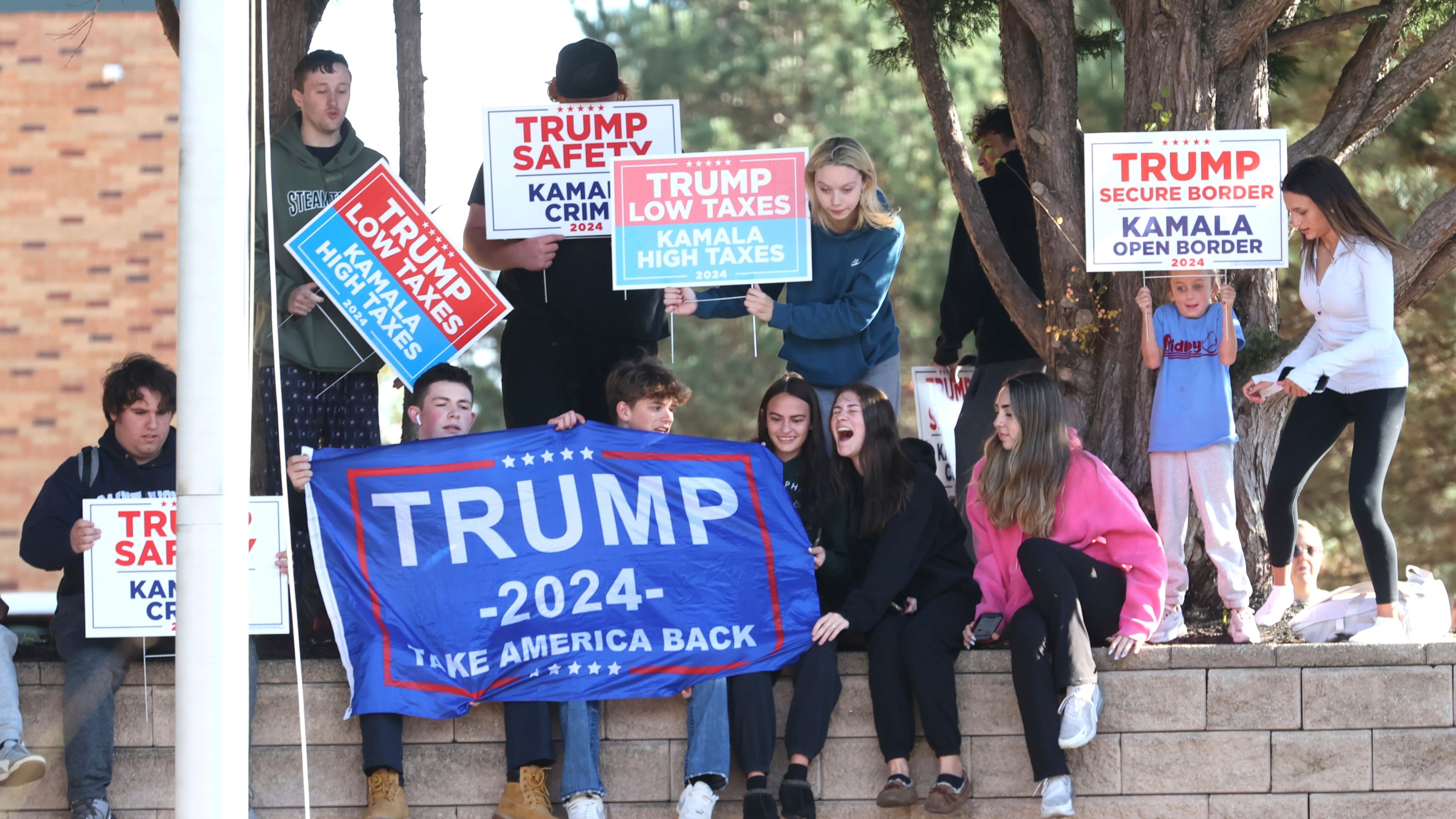 Young Trump supporters gather outside Ridley High School before Elon Musk leads a America PAC Town Hall in Delaware County, Pa., at Ridley High School on Thursday, Oct. 17, 2024. (Charles Fox/The Philadelphia Inquirer via AP)