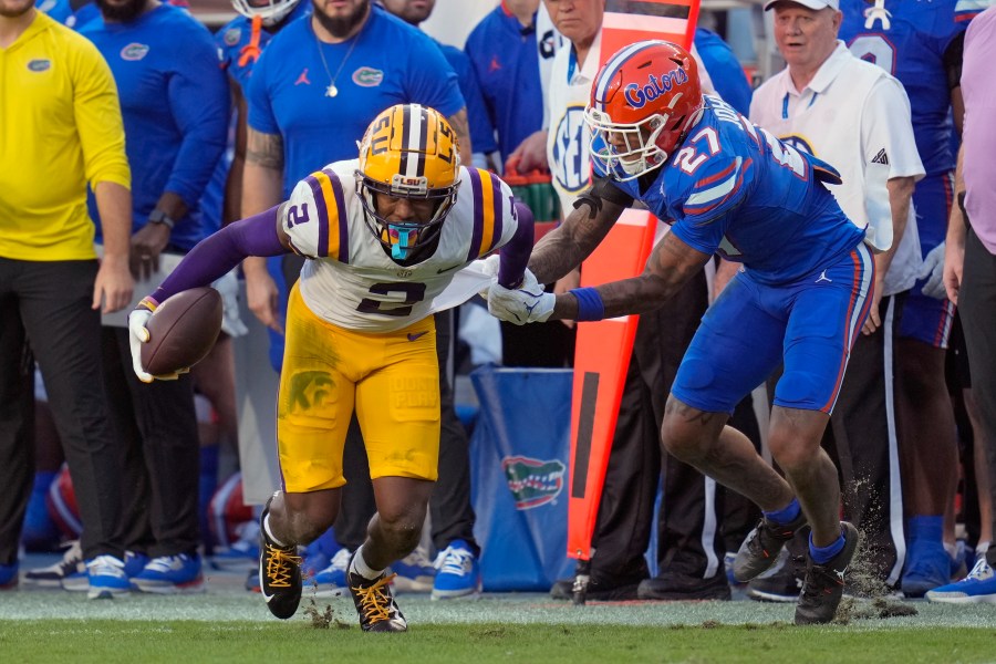 Florida defensive back Dijon Johnson (27) tries to stop LSU wide receiver Kyren Lacy (2) after a reception during the first half of an NCAA college football game, Saturday, Nov. 16, 2024, in Gainesville, Fla. (AP Photo/John Raoux)