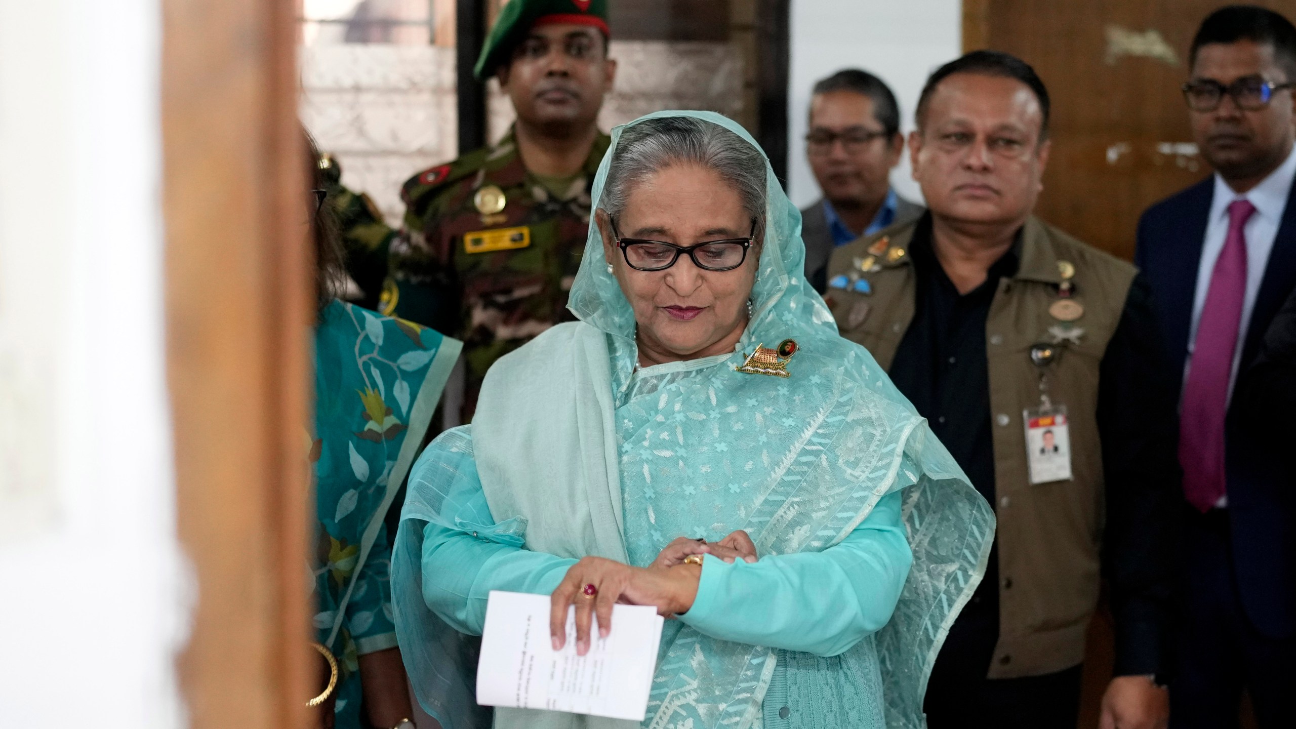 FILE- Bangladesh Prime Minister Sheikh Hasina checks her watch as she waits for the official opening time to cast her vote in Dhaka, Bangladesh, Jan. 7, 2024. (AP Photo/Altaf Qadri, File)