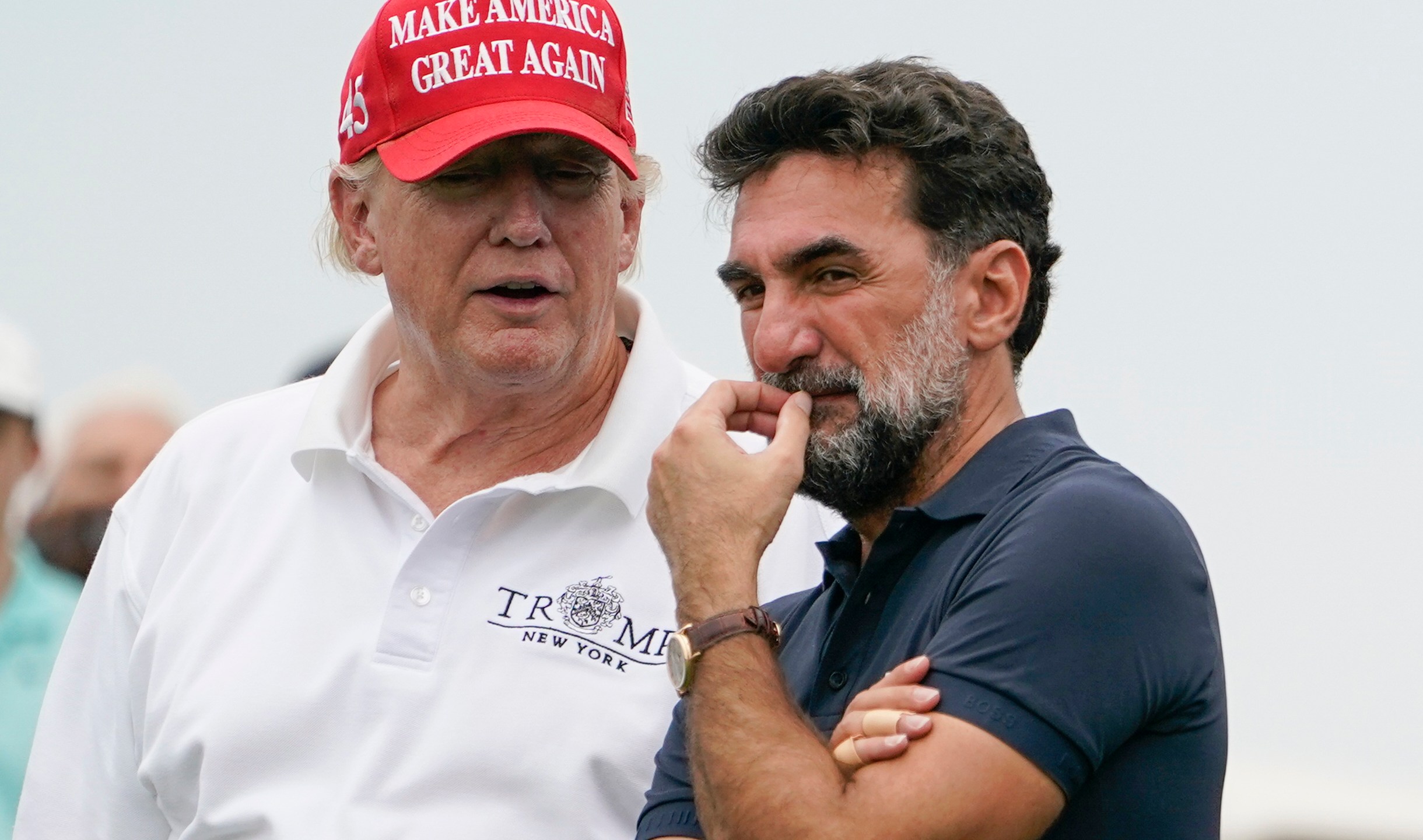 FILE - Former President Donald Trump, left, talks with Yasir Al-Rumayyan, governor of Saudi Arabia's Public Investment Fund, on the 16th hole during the first round of the Bedminster Invitational LIV Golf tournament in Bedminster, NJ., July 29, 2022. (AP Photo/Seth Wenig, File)