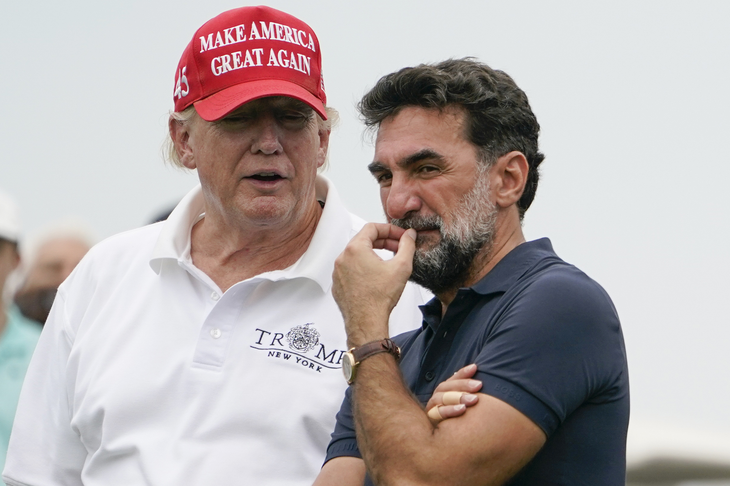 FILE - Former President Donald Trump, left, talks with Yasir Al-Rumayyan, governor of Saudi Arabia's Public Investment Fund, on the 16th hole during the first round of the Bedminster Invitational LIV Golf tournament in Bedminster, NJ., July 29, 2022. (AP Photo/Seth Wenig, File)