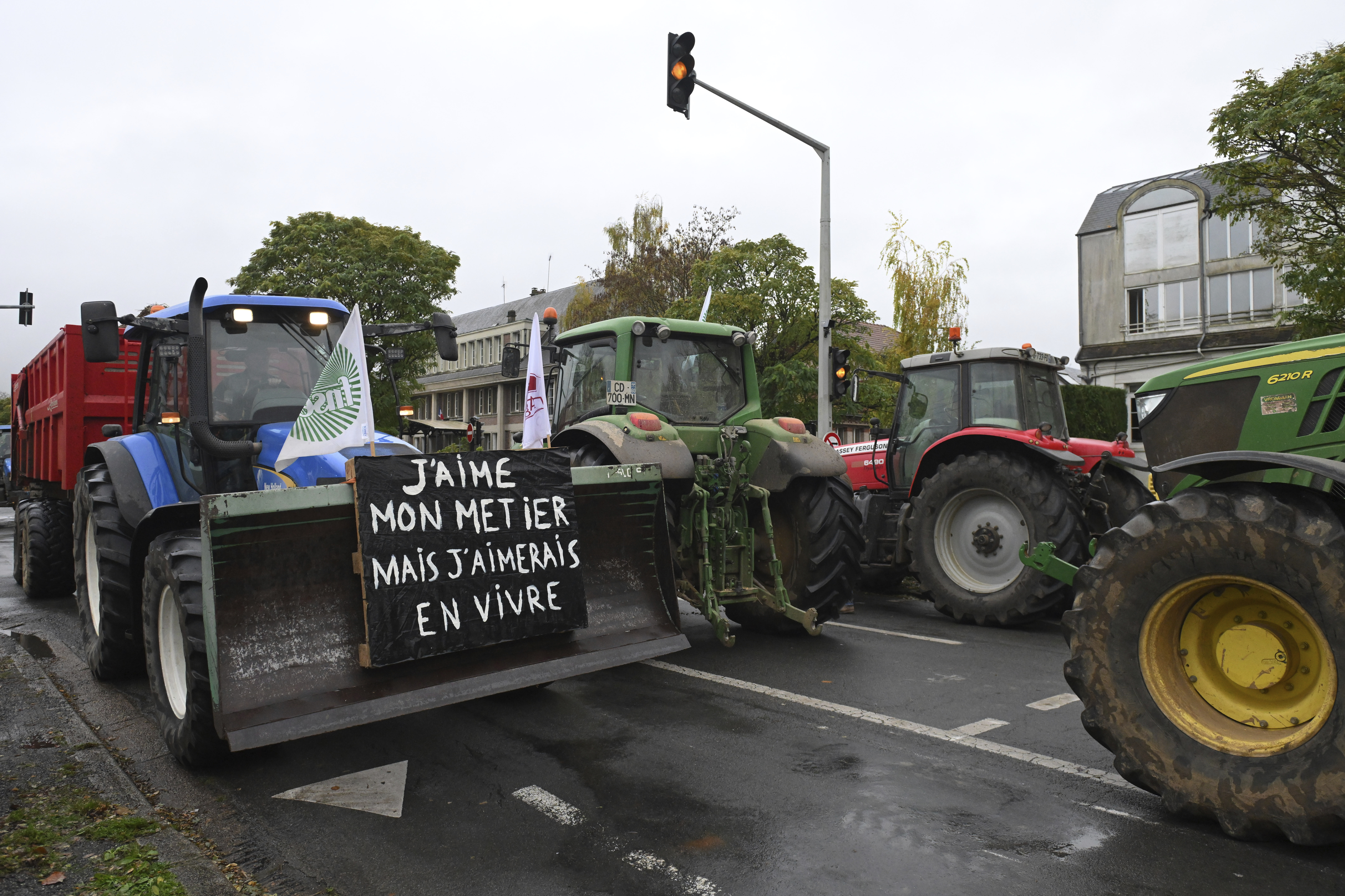 Farmers drive their tractors during a rally against the EU-Mercosur trade agreement, Monday, Nov. 18, 2024 in Beauvais, northern France. Poster reads: I love my job and would like to live on it.(AP Photo/Matthieu Mirville)