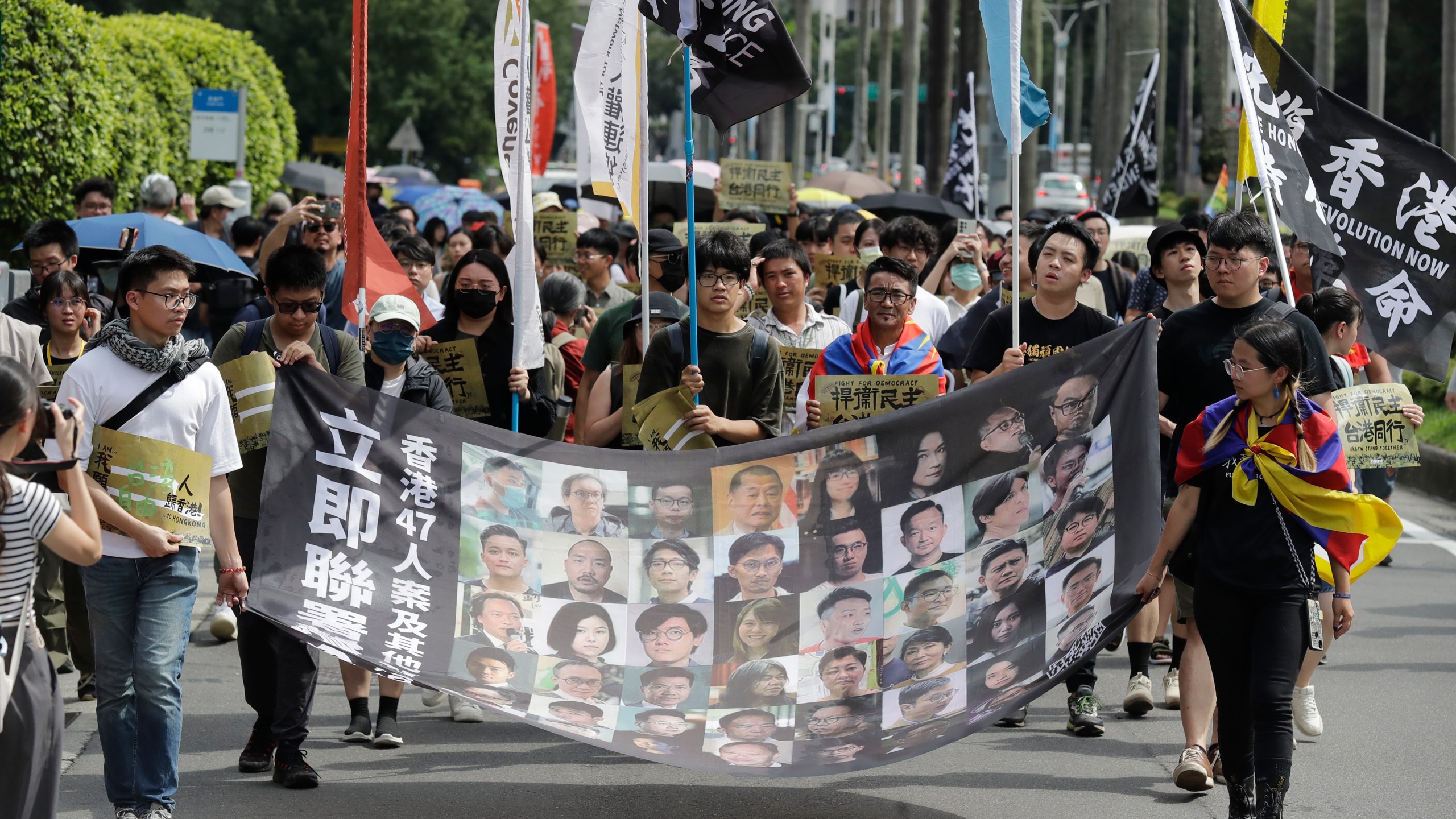 FILE- Hong Kong activists and supporters march with a banner which reads " Unite now in solidarity with the Hong Kong 47 and other political prisoners" during a protest commemorating the 10th anniversary of the 2014 umbrella movement and the fifth anniversary of the anti-extradition law amendment bill movement in Taipei, Taiwan, June 9, 2024. (AP Photo/Chiang Ying-ying, File)