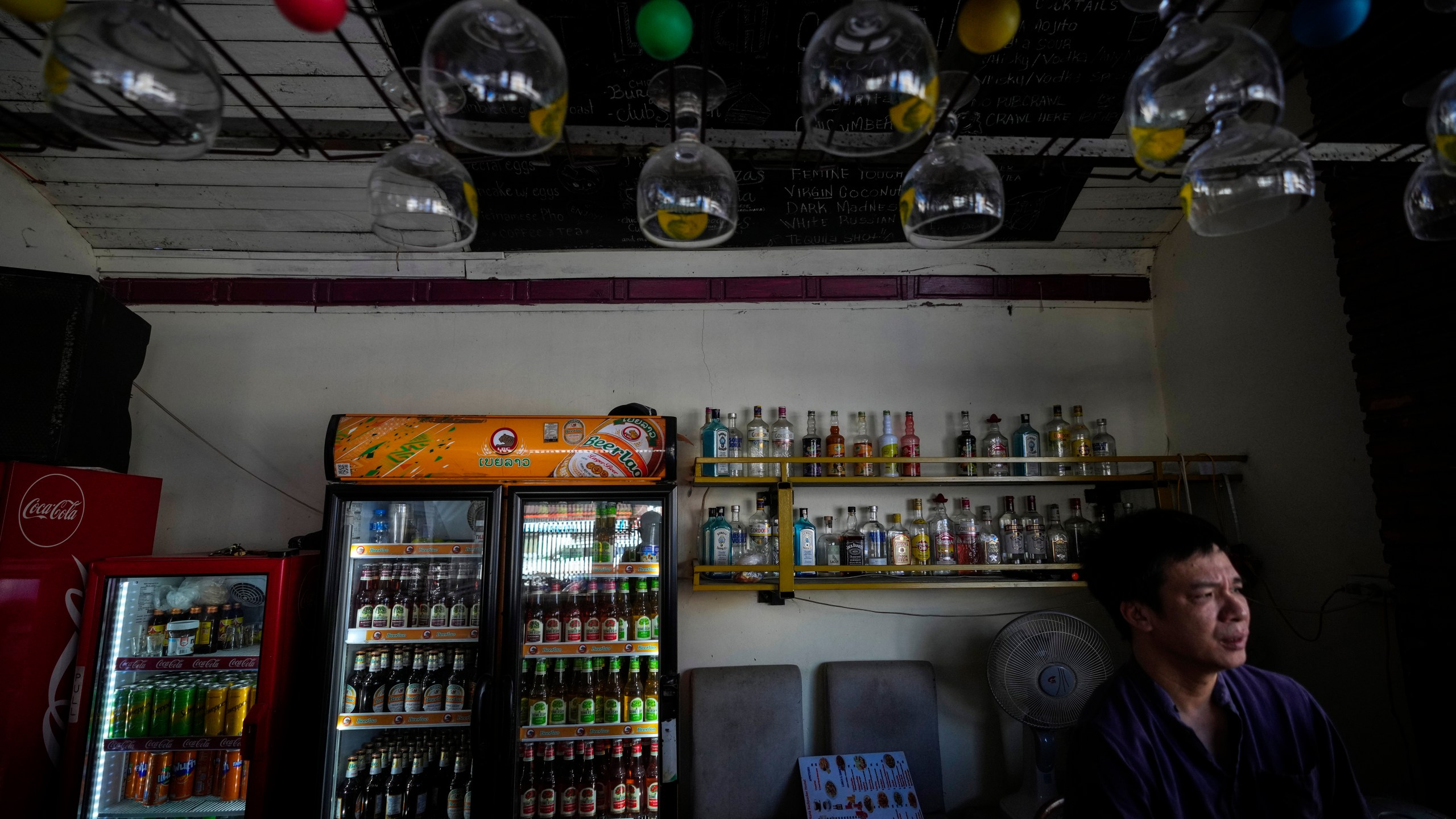 Duong Duc Toan, the manager of Nana Backpack hostel sits in the bar of the hostel in Vang Vieng, Laos, Tuesday, Nov. 19, 2024. (AP Photo/Anupam Nath)