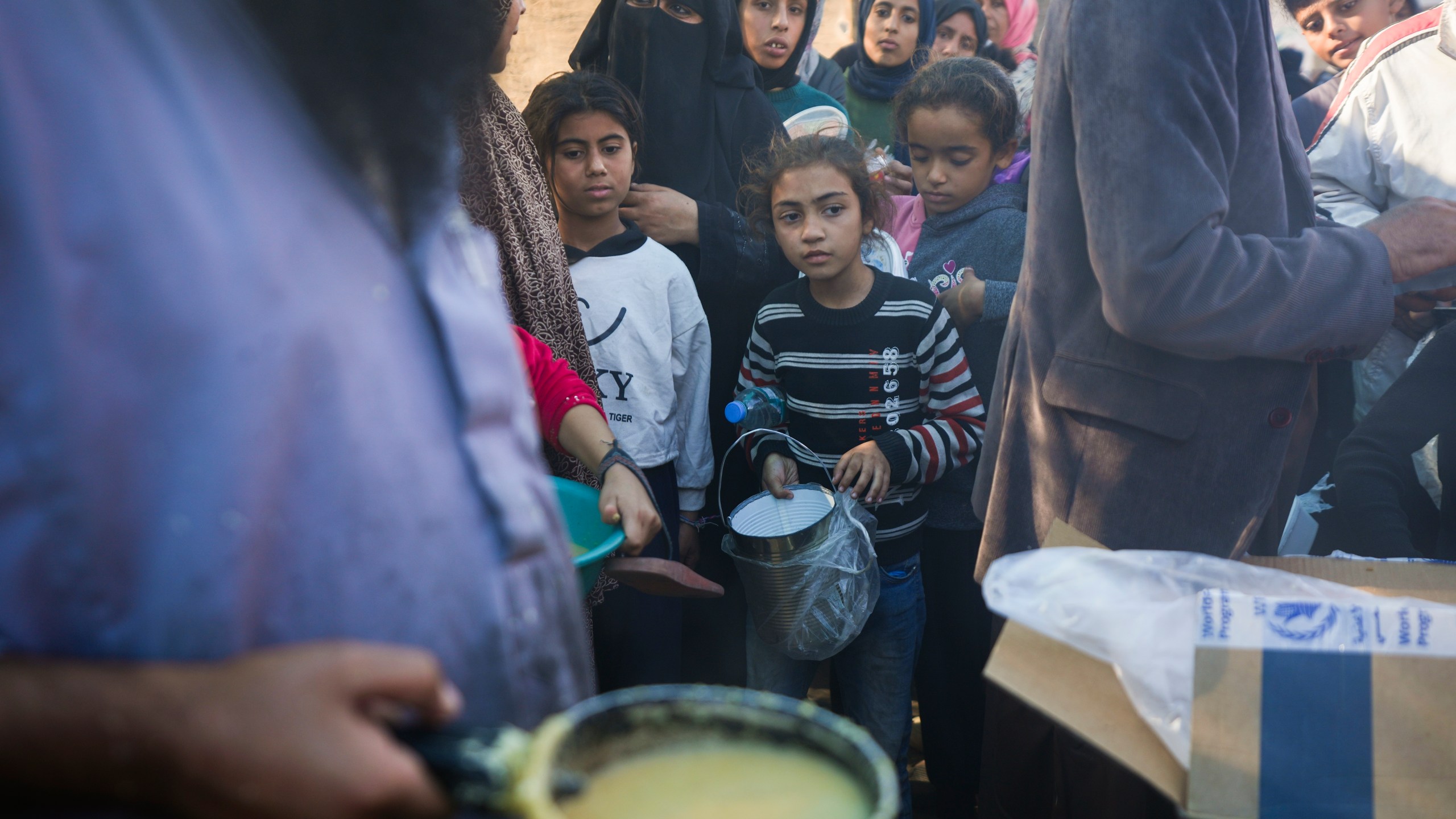 Palestinians queue for food in Deir al-Balah, Gaza Strip, Monday, Nov. 18, 2024. (AP Photo/Abdel Kareem Hana)