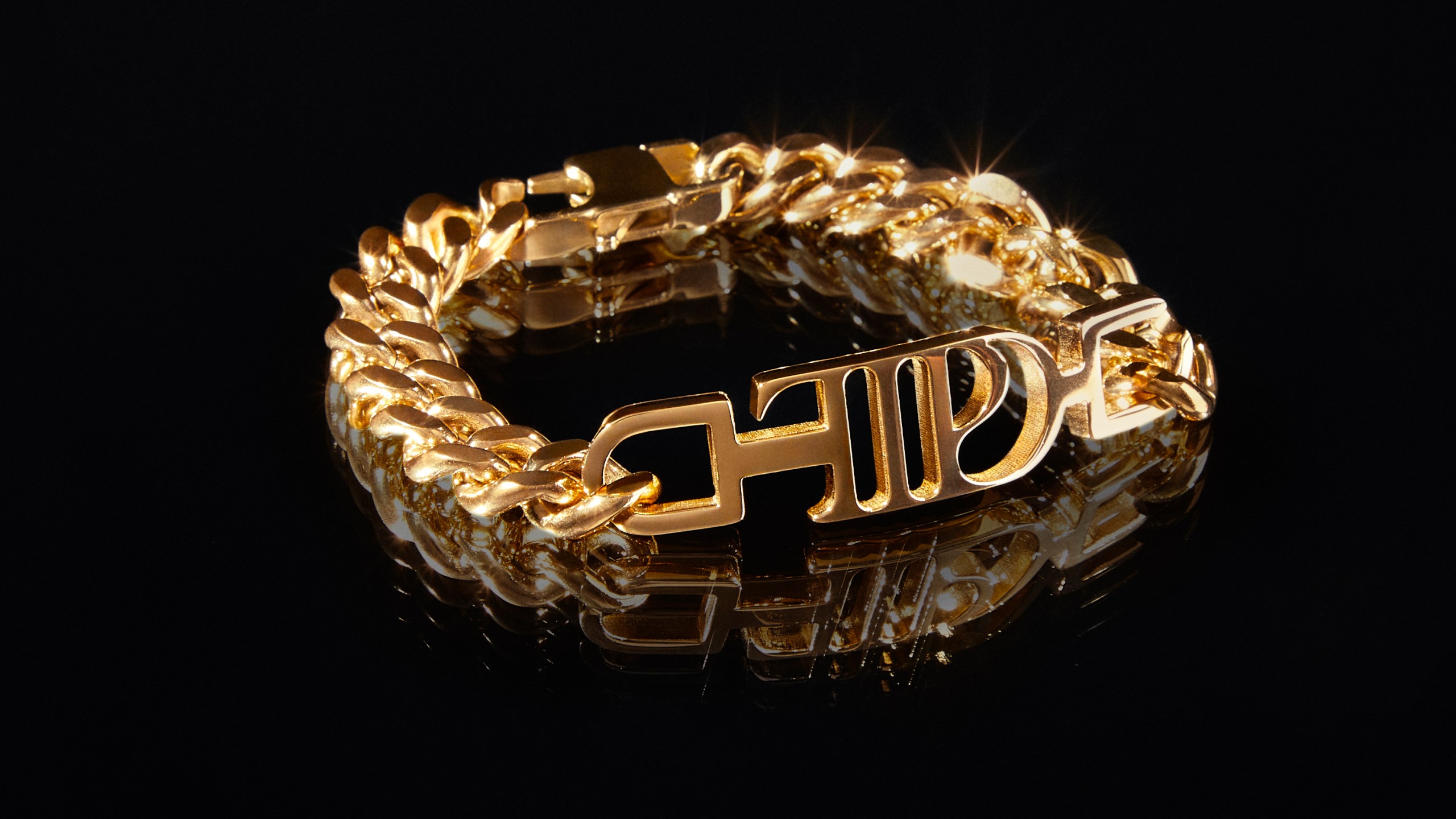 This image shows a gold-plated chain link bracelet, featuring the logo for Taylor Swift's album, "The Tortured Poets Department." (TAS Rights Management via AP)