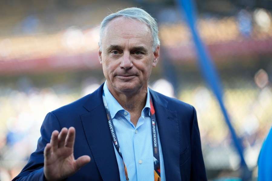 Commissioner of Major League Baseball, Rob Manfred walks on the field before Game 2 of the baseball World Series between the Los Angeles Dodgers and the New York Yankees, Saturday, Oct. 26, 2024, in Los Angeles. (AP Photo/Ashley Landis)