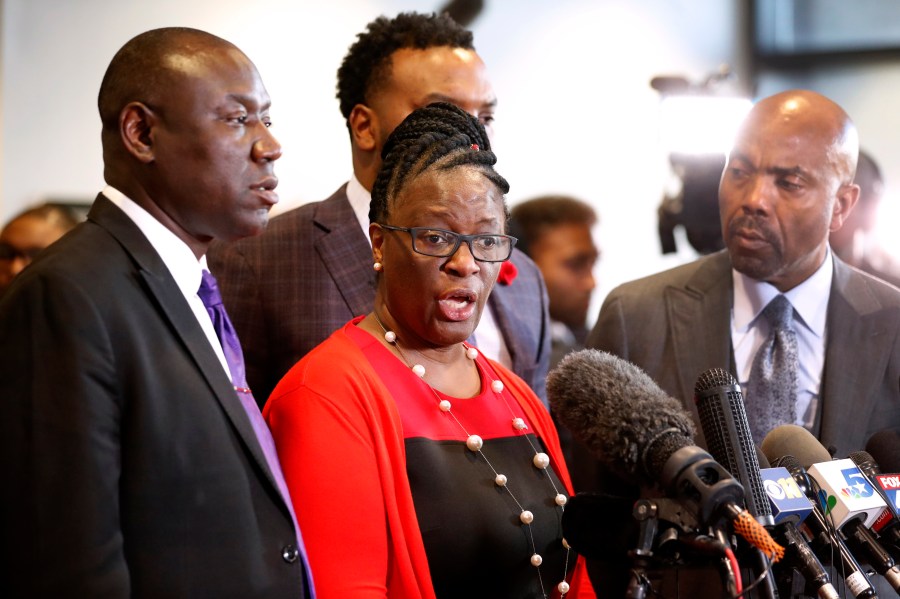 FILE - Allison Jean, center, mother of Botham Jean, makes comments during a news conference as attorneys Ben Crump, left, Lee Merritt, rear, and Daryl Washington, right, look on after the sentencing phase of former Dallas police officer Amber Guyger's murder trial at Frank Crowley Court Building in Dallas, Oct. 2, 2019. (AP Photo/Tony Gutierrez, File)